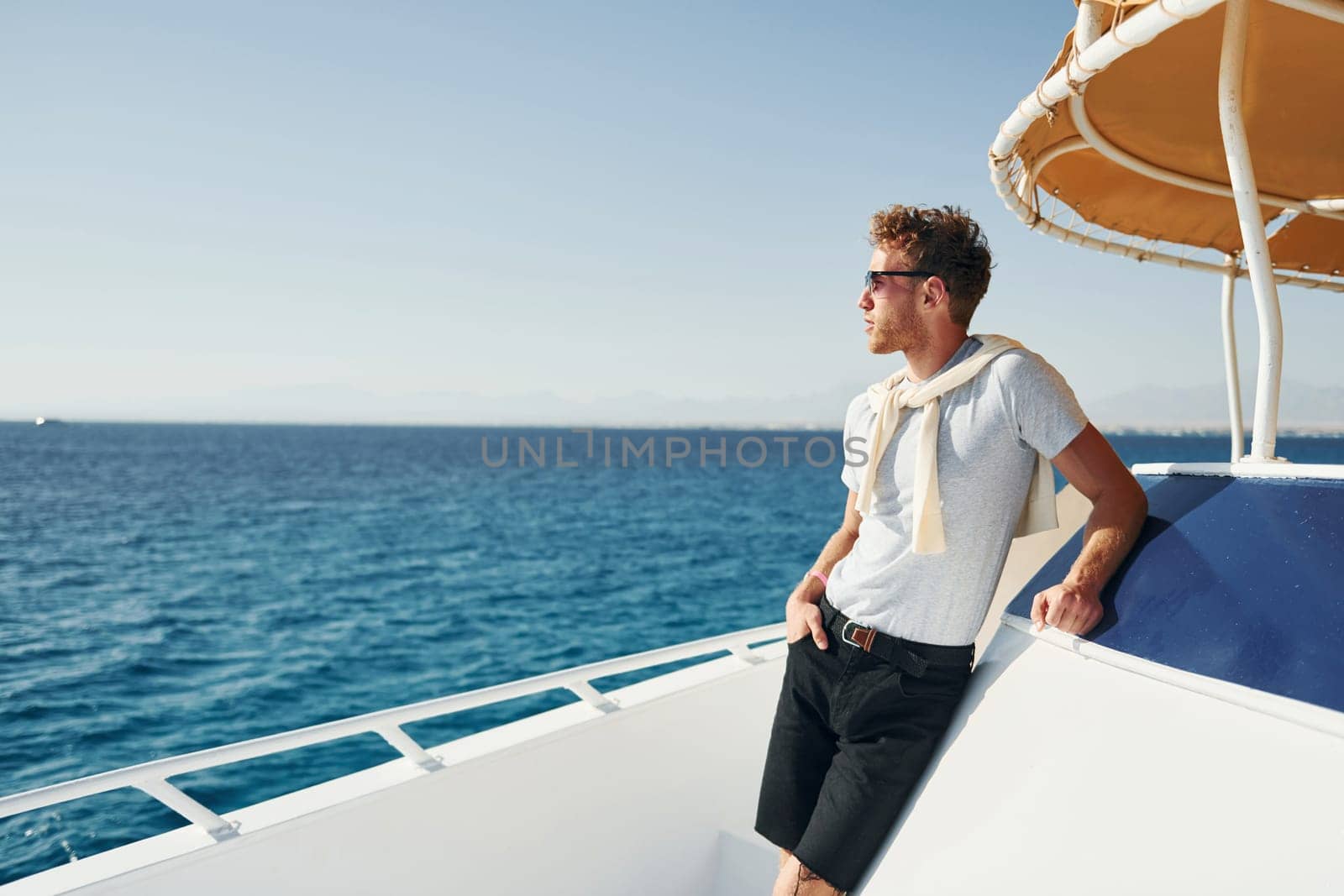 Young male tourist is on the yacht on the sea. Conception of vacation.