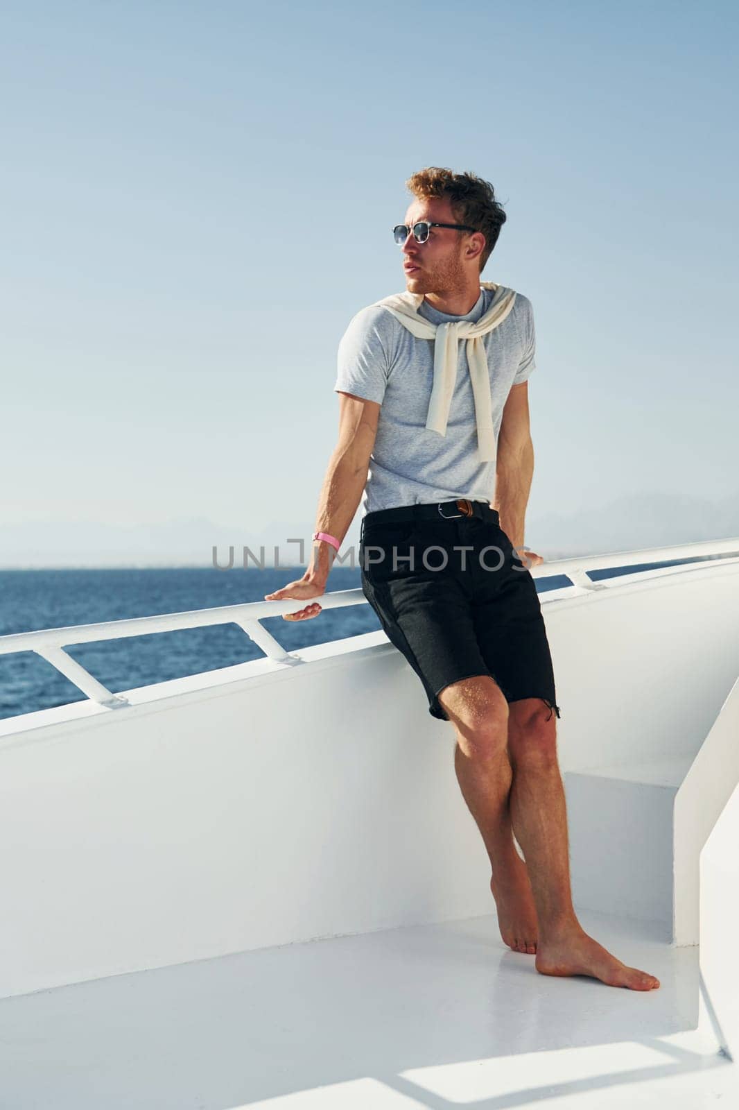 Young male tourist is on the yacht on the sea. Conception of vacation.
