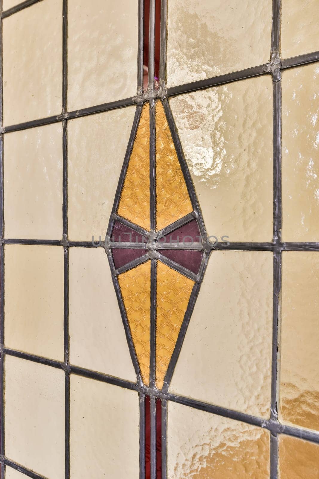 a stained glass window on a wall in an old building, with the sun reflecting off it's surface