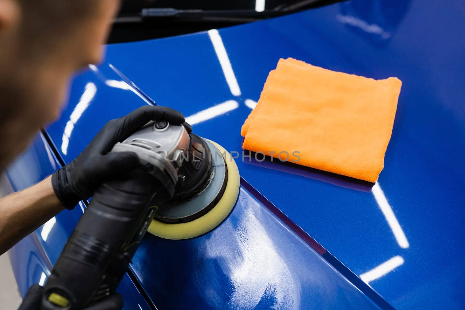 Abrasive paste car polishing with orbital polisher for remove scratches. Worker of detailing auto service making final polishing for car. by Rabizo