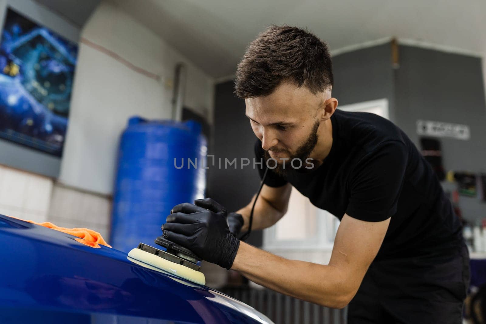 Abrasive paste car polishing with orbital polisher for remove scratches. Worker of detailing auto service making final polishing for car. by Rabizo