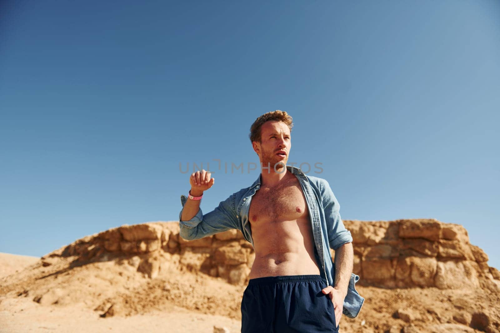 Shows body. Young european man have vacation and enjoying free time on the beach of sea.