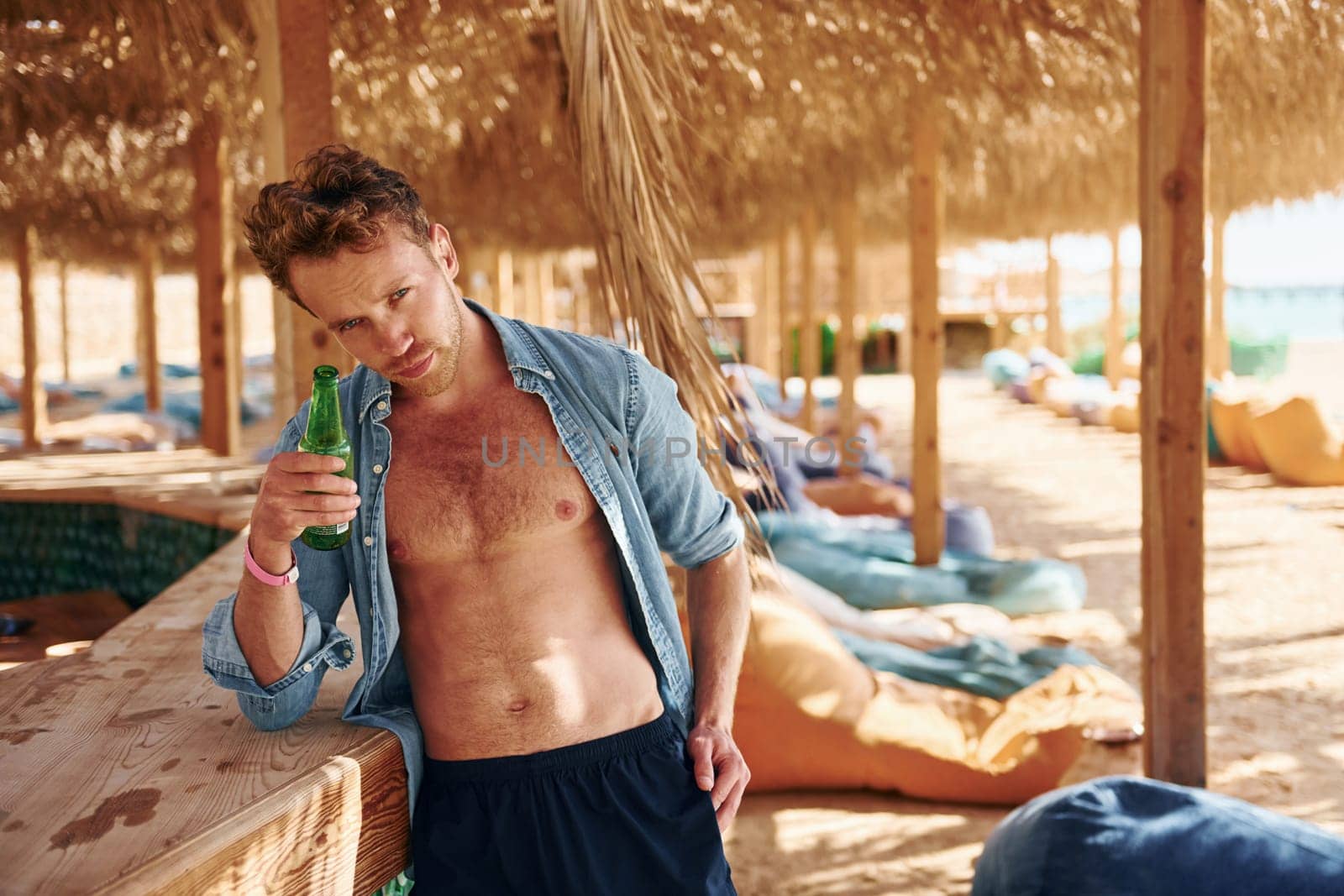 Shows body. Young european man have vacation and enjoying free time on the beach of sea.