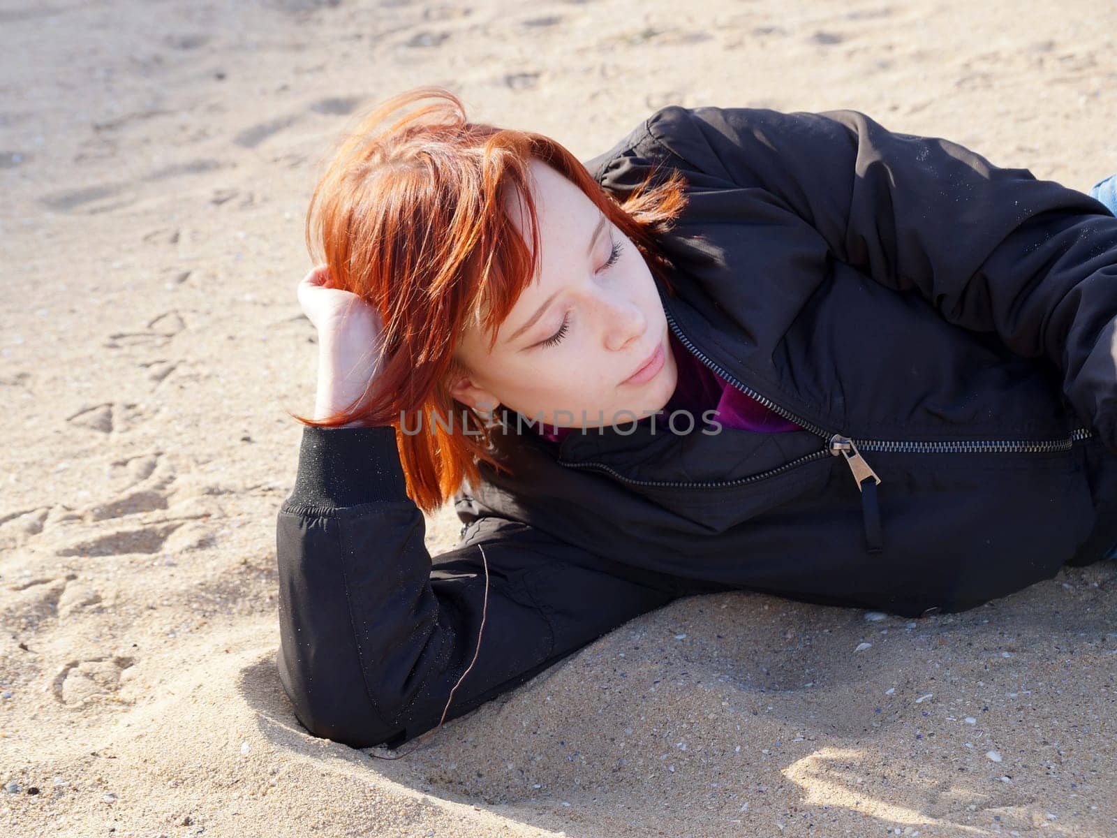 portrait of a red-haired teenage girl lying on the sand by Annado