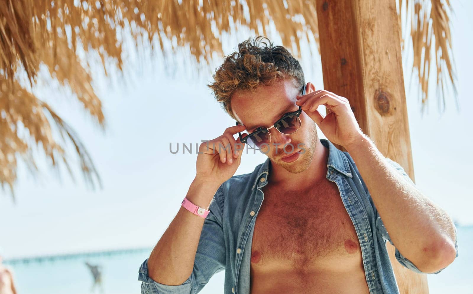 Posing for a camera. Young european man have vacation and enjoying free time on the beach of sea.