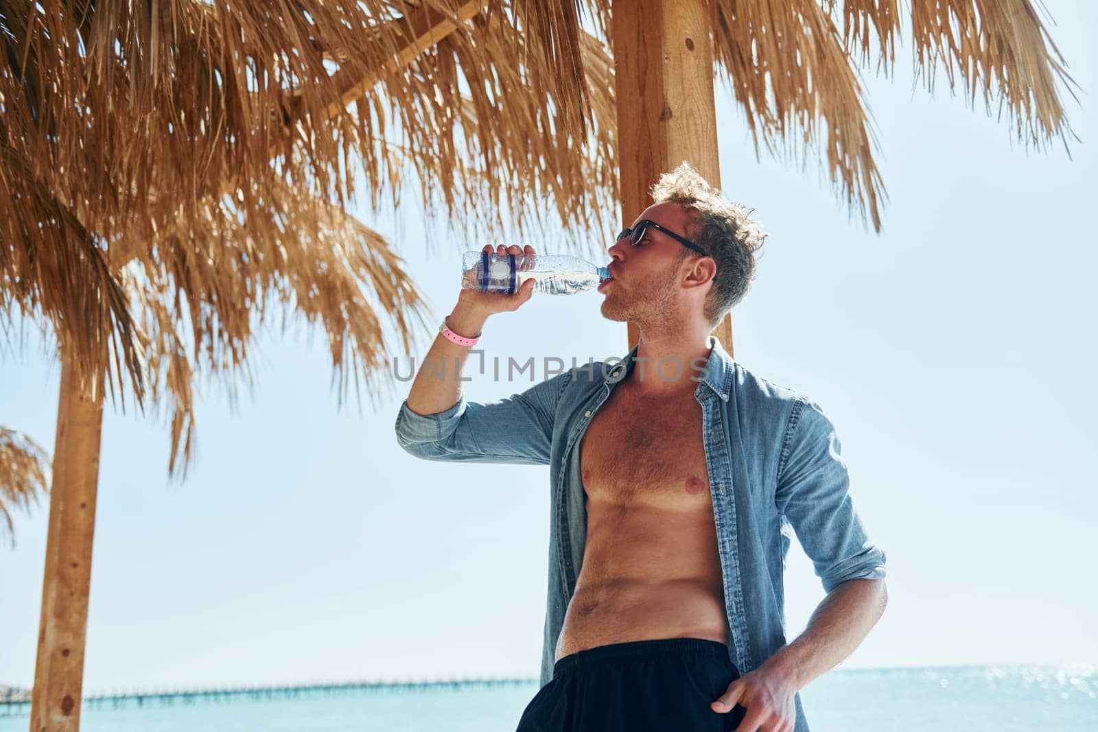 Posing for a camera. Young european man have vacation and enjoying free time on the beach of sea.