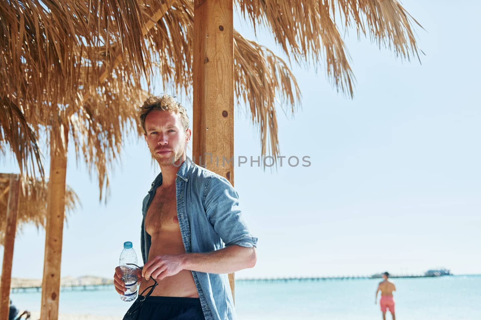 Posing for a camera. Young european man have vacation and enjoying free time on the beach of sea.