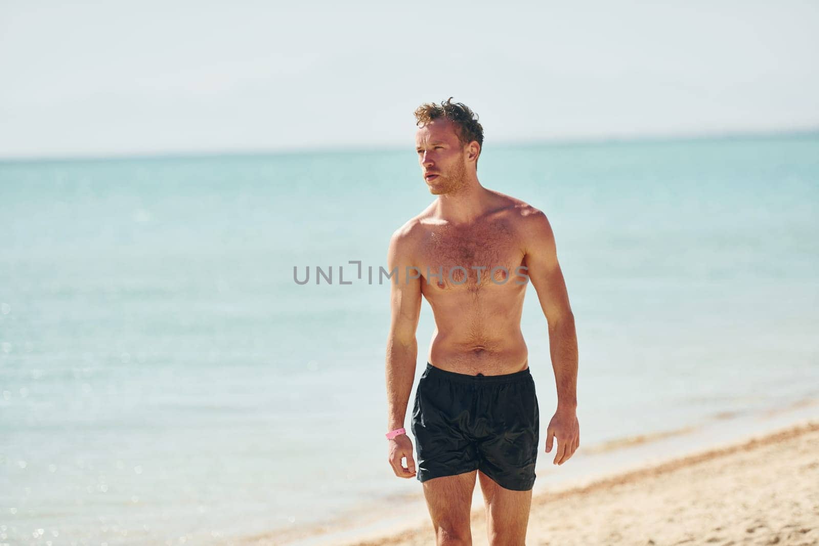 Clear water. Young european man have vacation and enjoying free time on the beach of sea.