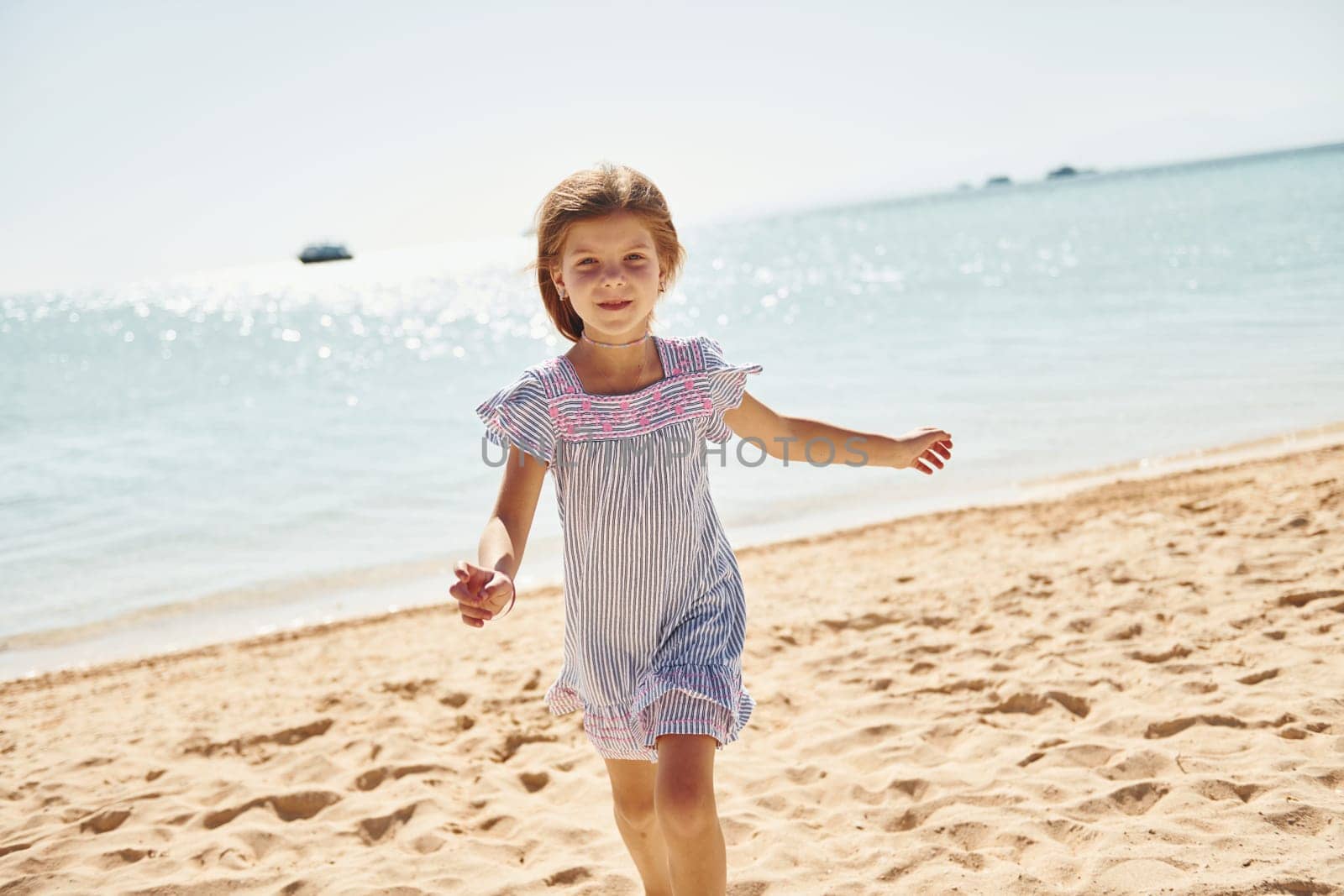 Little girl have vacation on the sea at sunny daytime. Conception of travel.