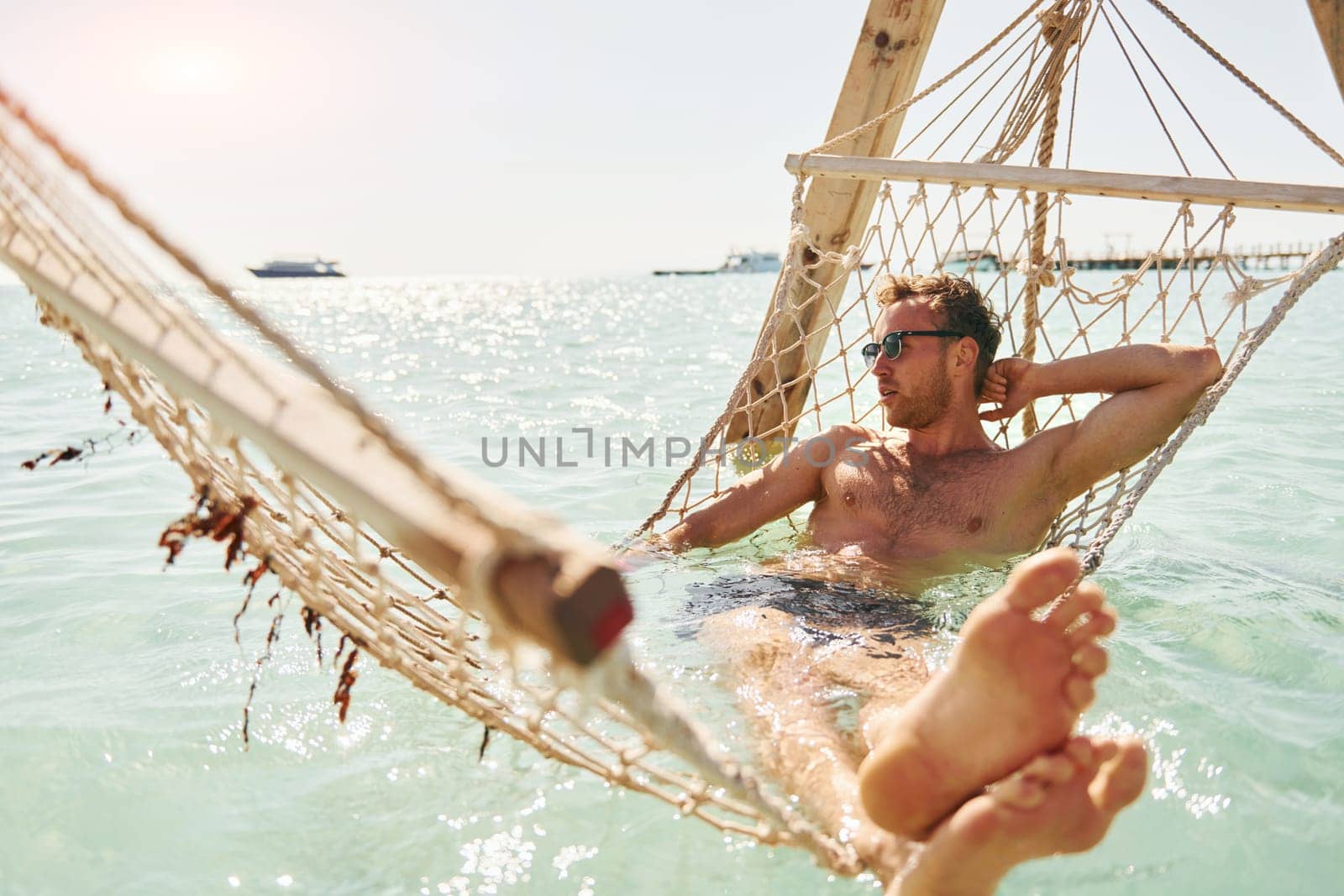 In sunglasses. Young european man have vacation and enjoying free time on the beach of sea.