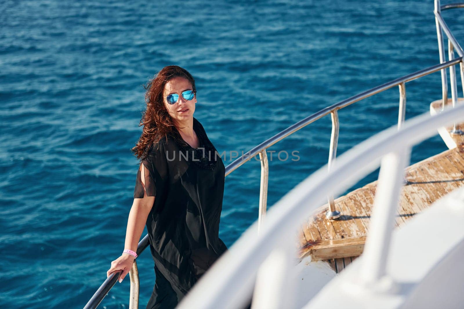 Mature woman standing on the yacht and enjoying her vacation on the sea.