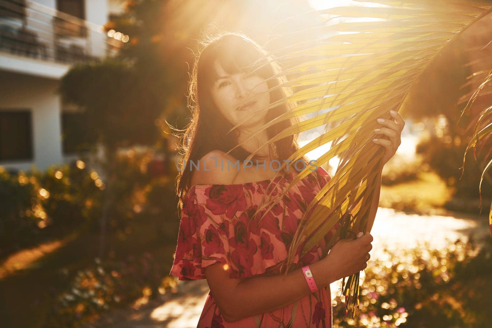 Happy mature woman is outdoors enjoying her vacation at sunny daytime by Standret