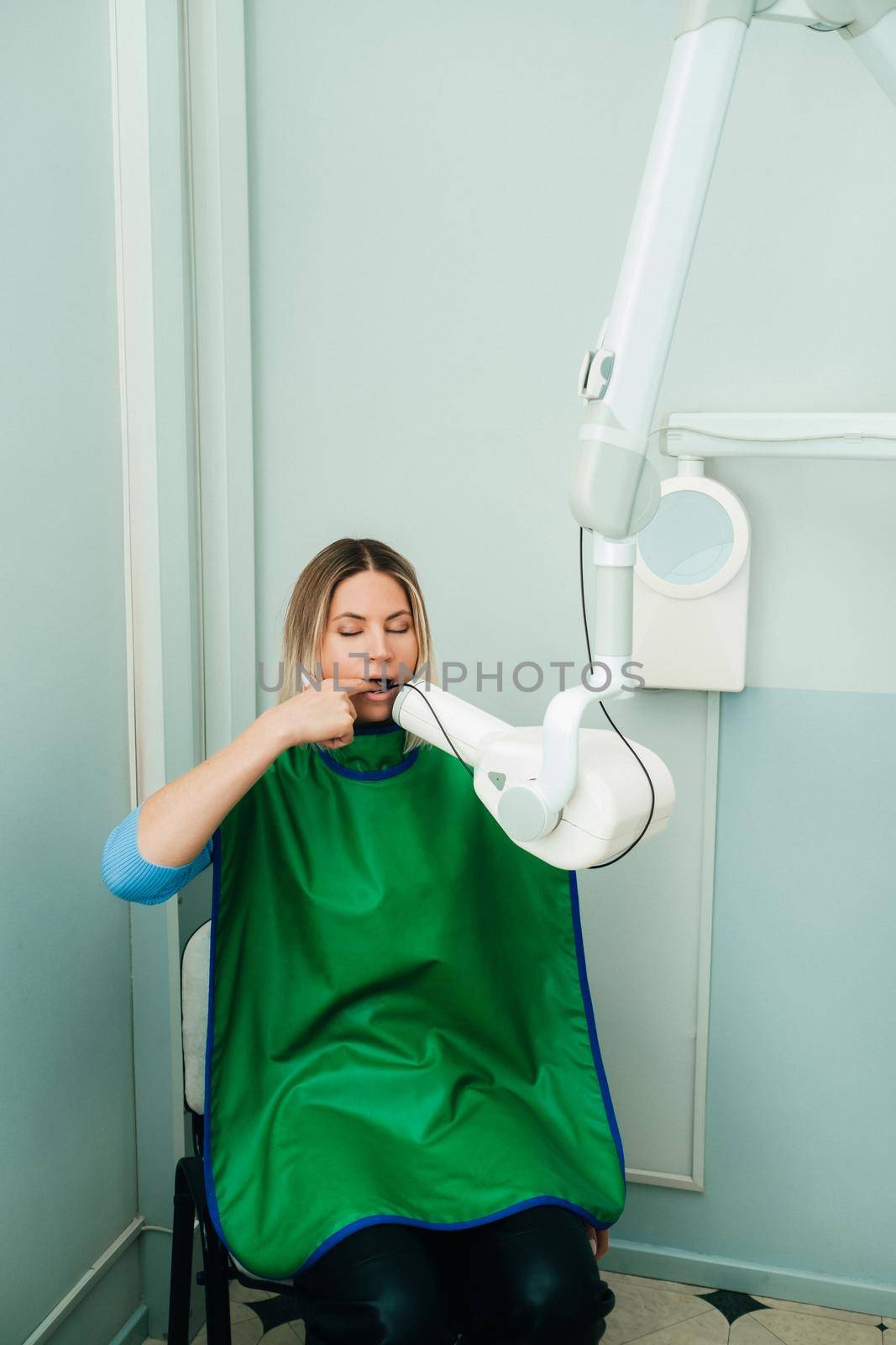 They take a picture of the girl in the X-ray dental office in the hospital.