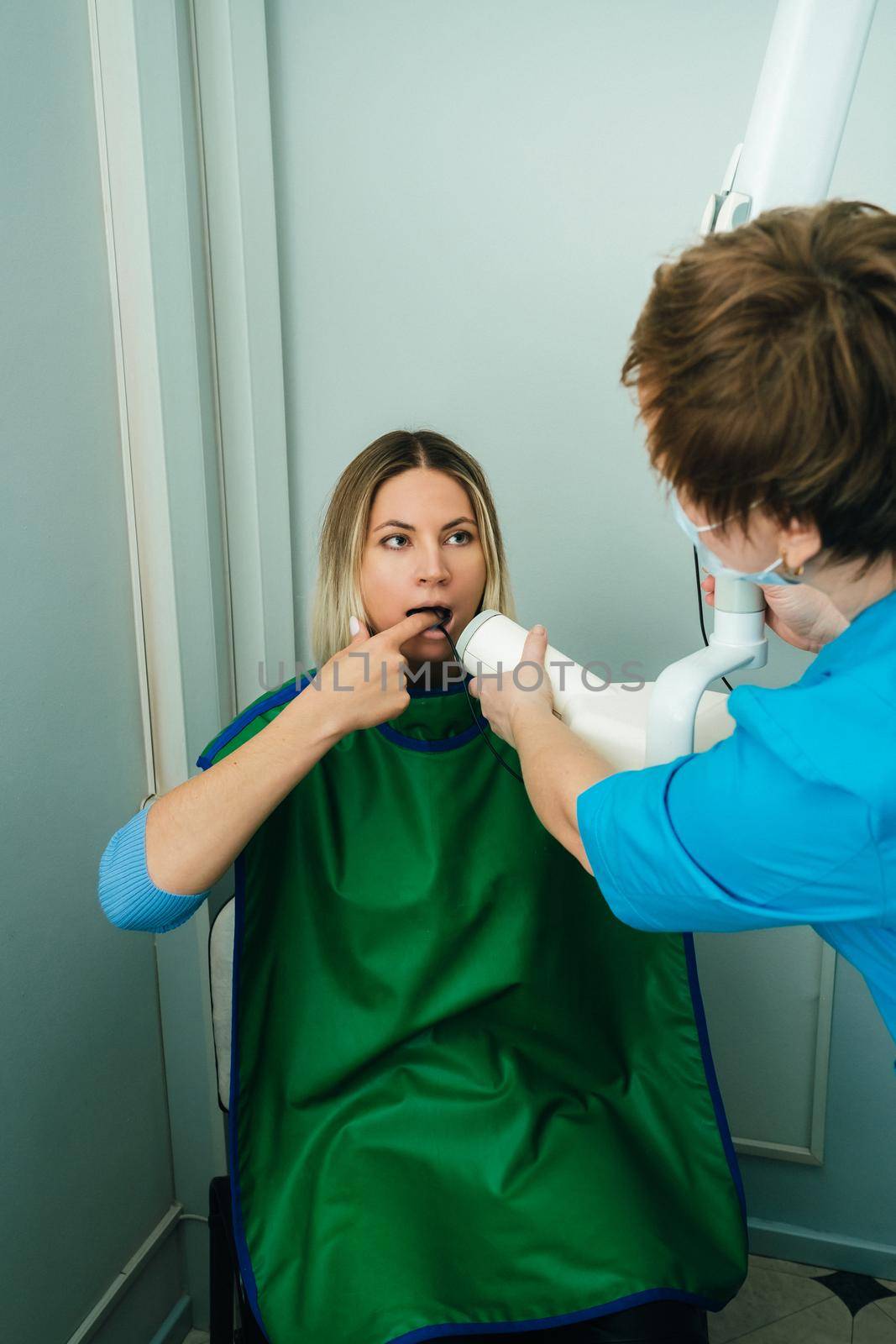 They take a picture of the girl in the X-ray dental office in the hospital.