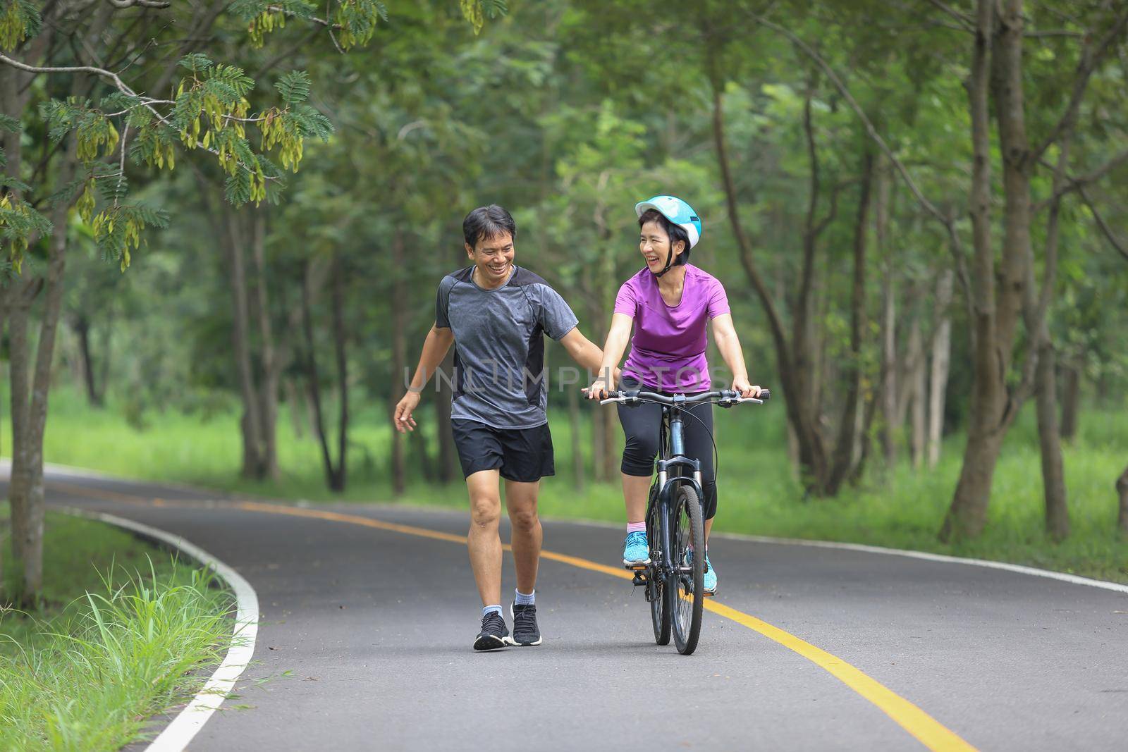 Asian middle aged couple exercise and relaxing in park