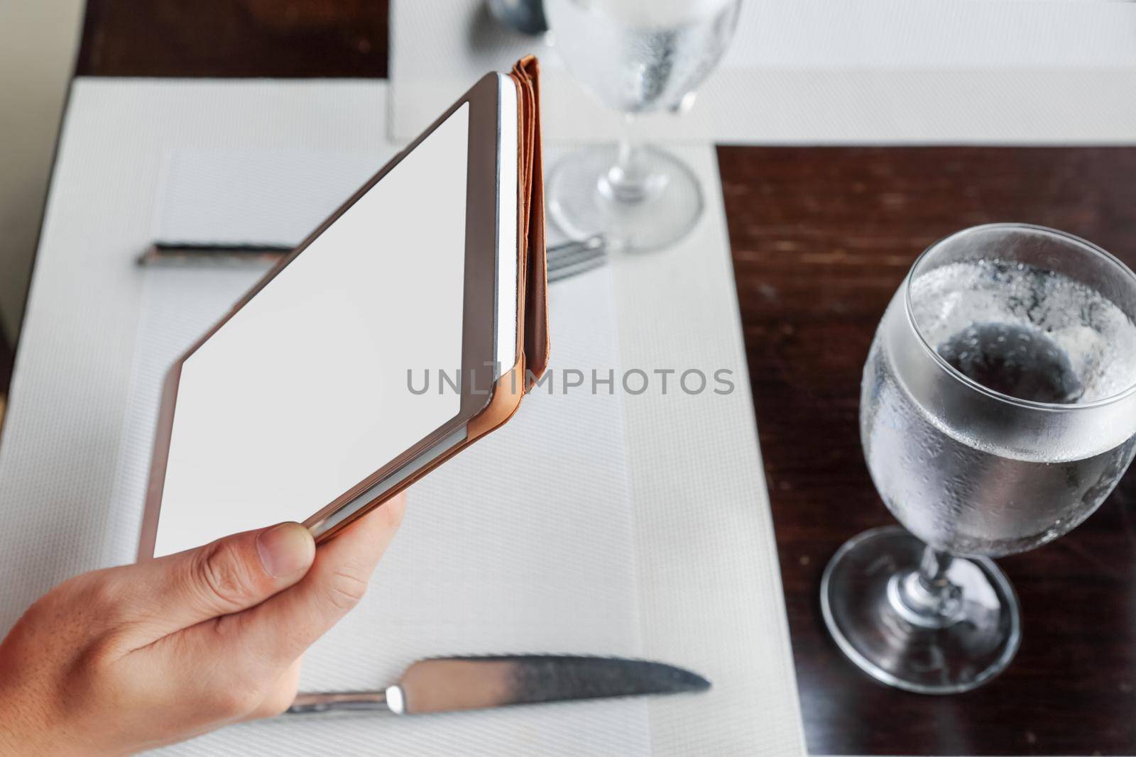 woman sitting using a tablet on dining table in restaurant