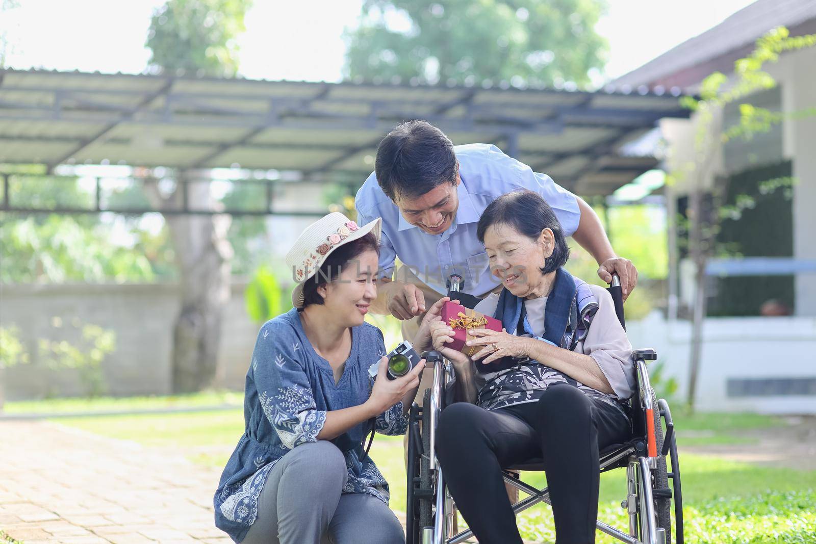 Son and daughter in law gift elderly mother in backyard