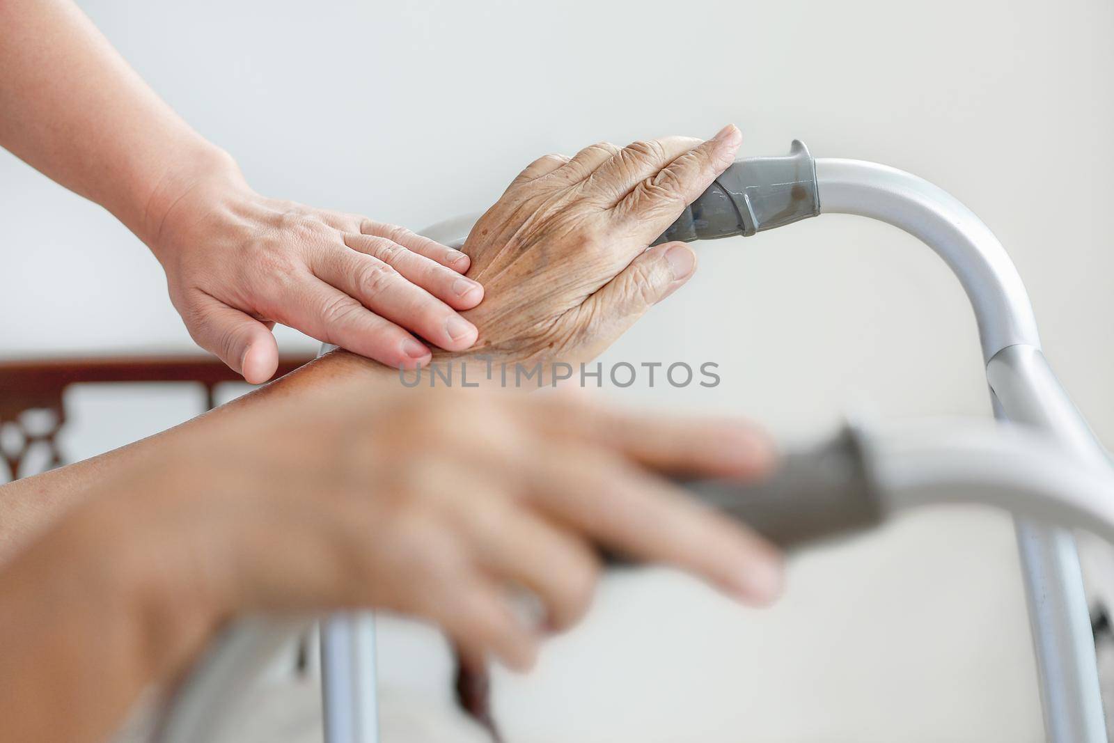 Elderly asian woman using a walker at home with caregiver take care