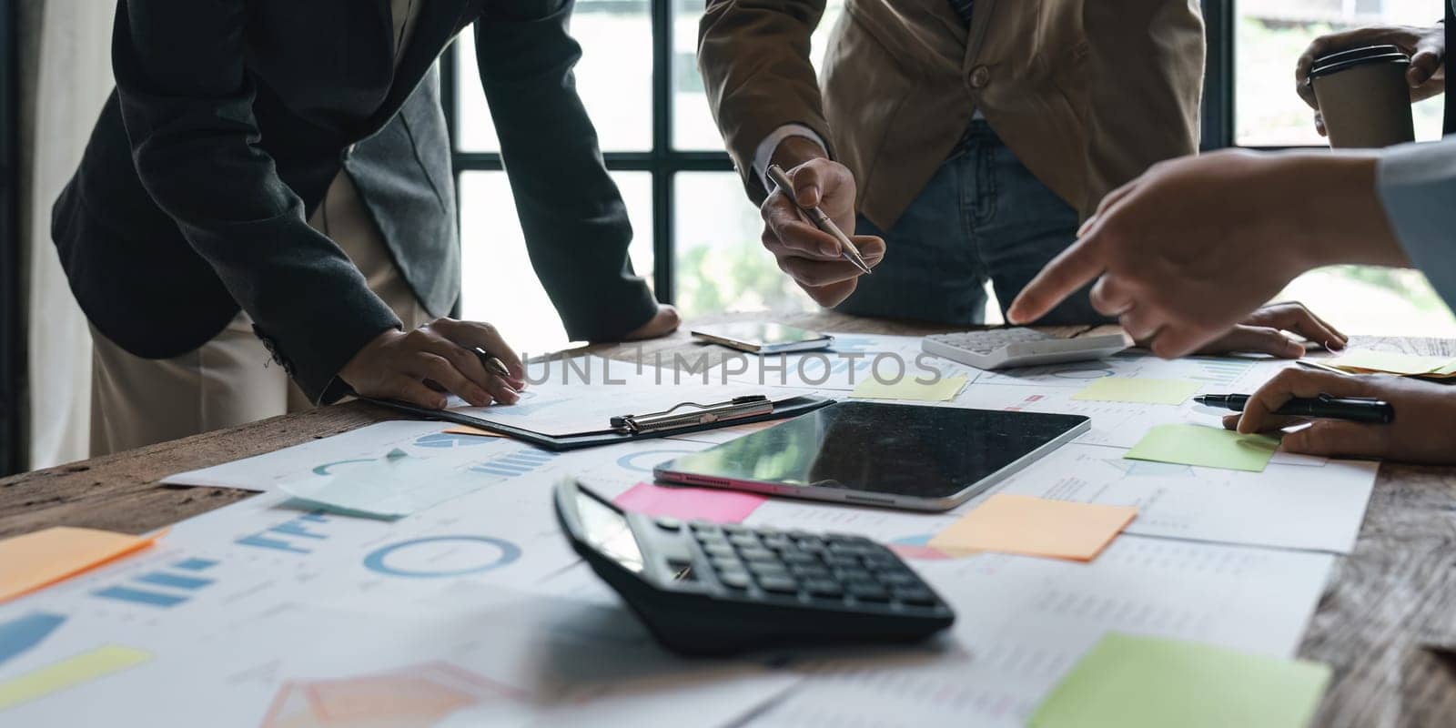 Business People Meeting using laptop computer, calculator, stock market chart paper for analysis planning to improve quality next month. Conference Discussion Corporate Concept.