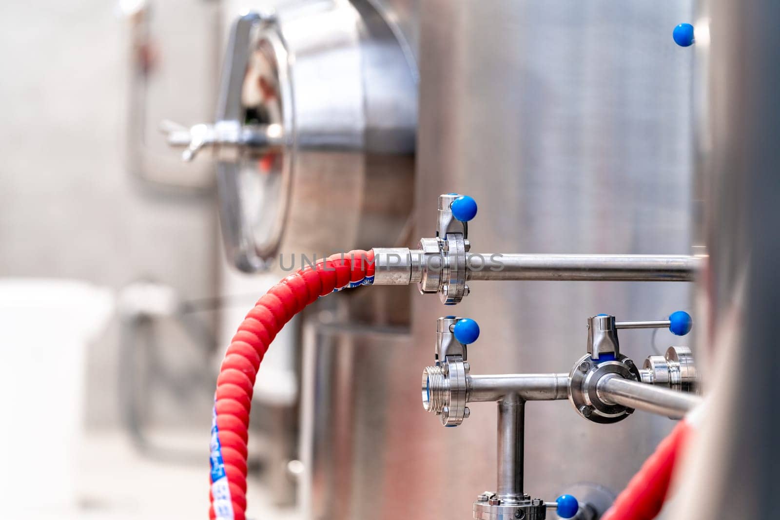 stainless steel boilers and vessels with pipes for brewing beer in a brewery.