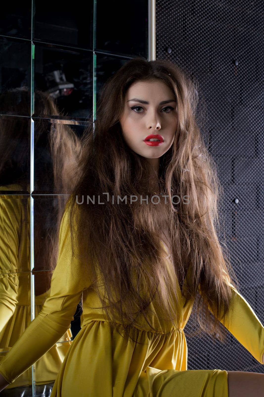 Portrait of beautiful brunette woman near mirror