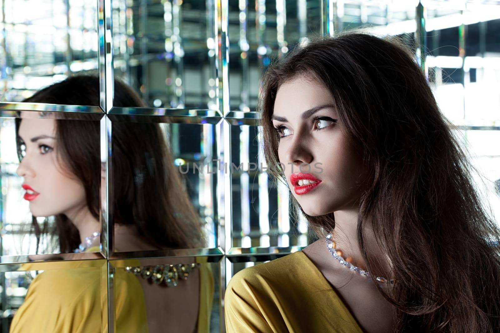 Portrait of beautiful brunette woman near mirror