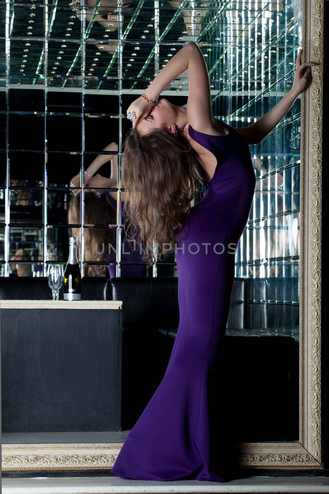 Full length portrait of beautiful woman in purple dress in nightclub