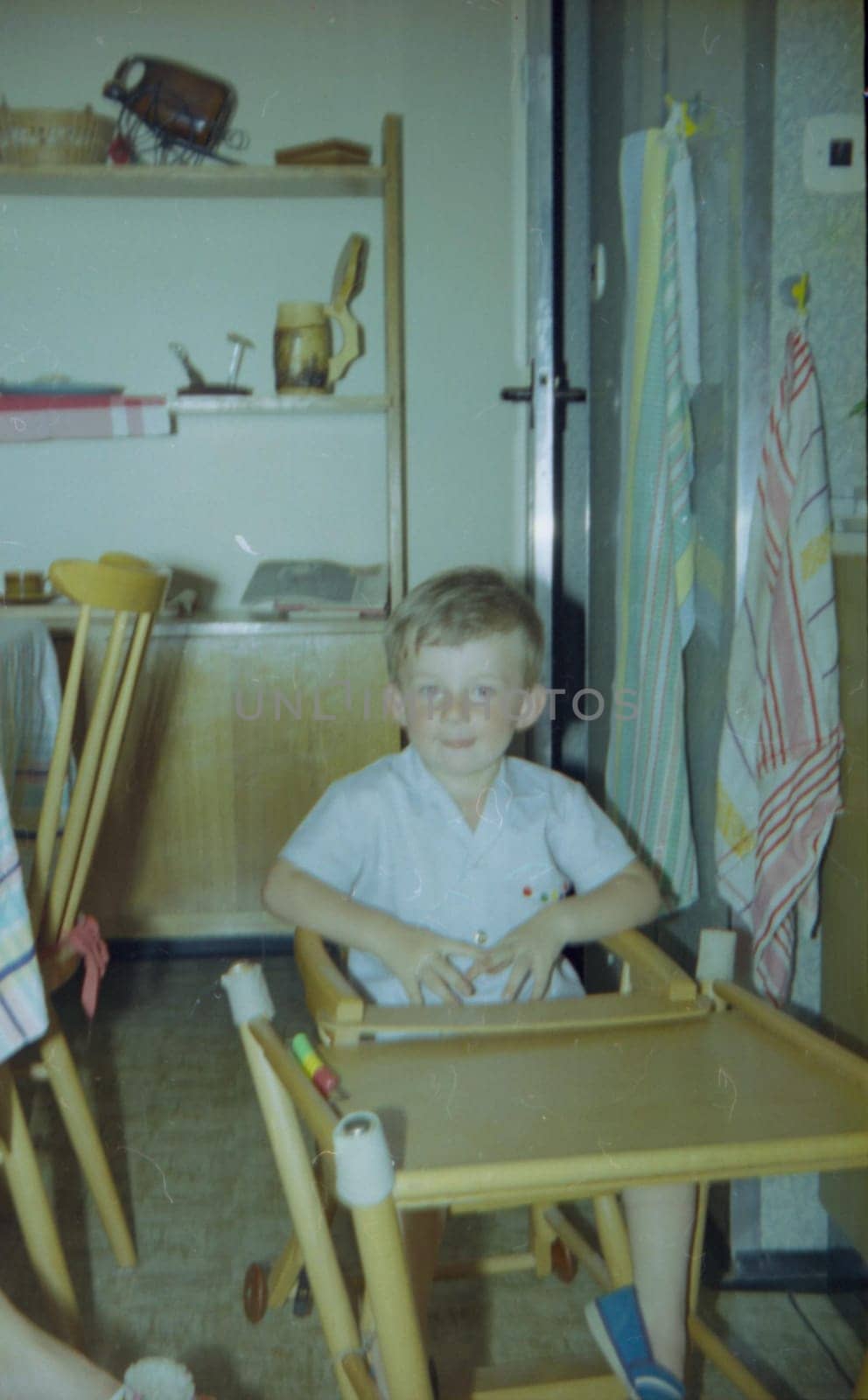 THE CZECHOSLOVAK SOCIALIST REPUBLIC - 1973: Retro photo shows small boy sits on baby chair and table - highchair.