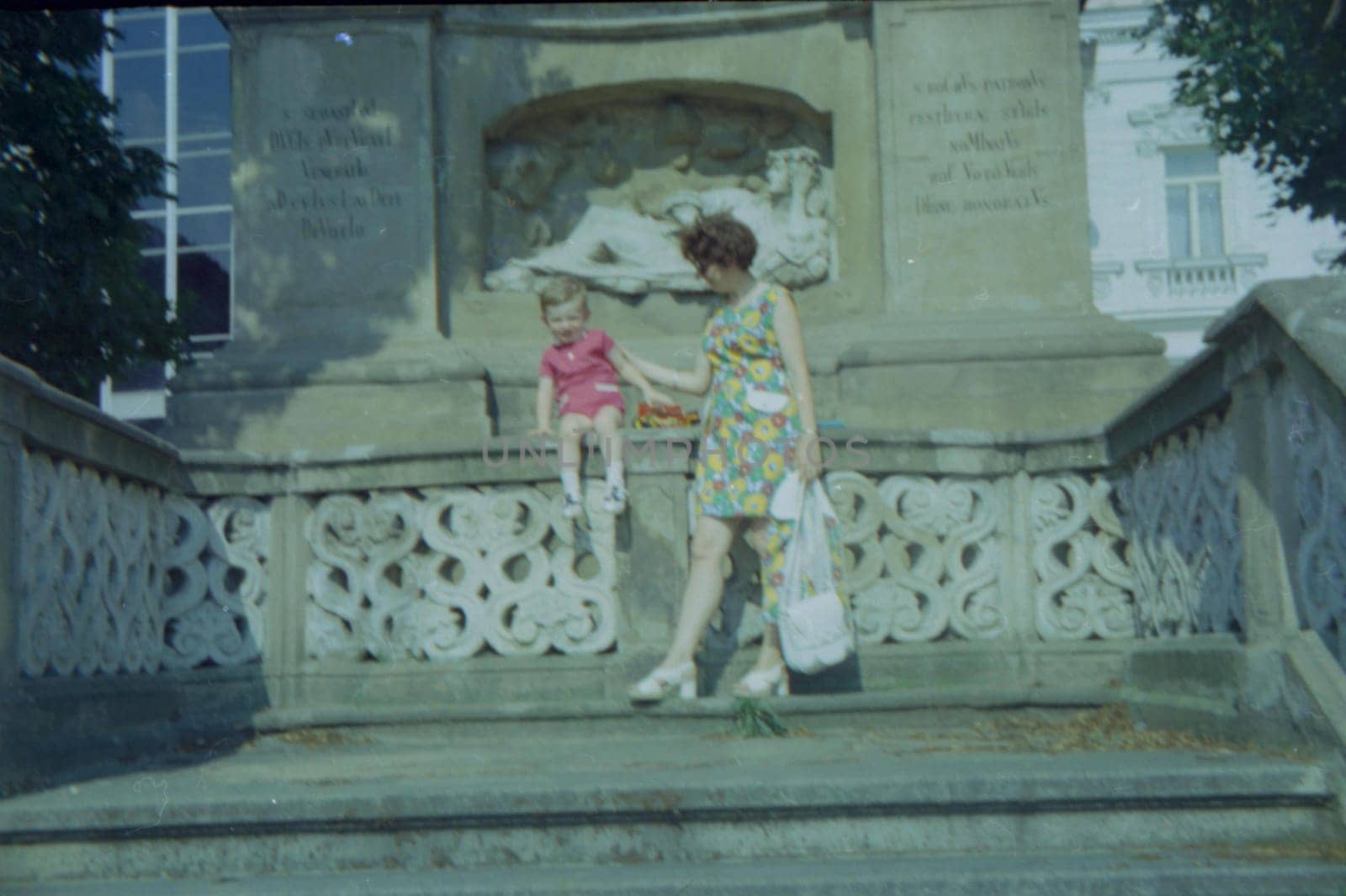 THE CZECHOSLOVAK SOCIALIST REPUBLIC - 1973: Retro photo shows mother and son with toy outdoors.