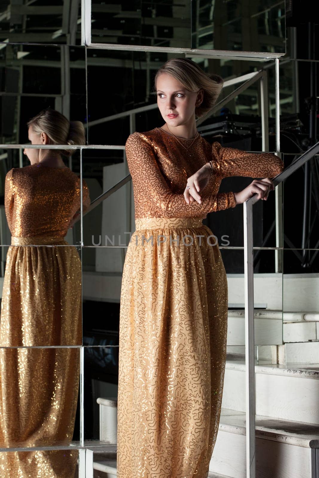 Slim blonde posing in fashionable golden dress, close-up