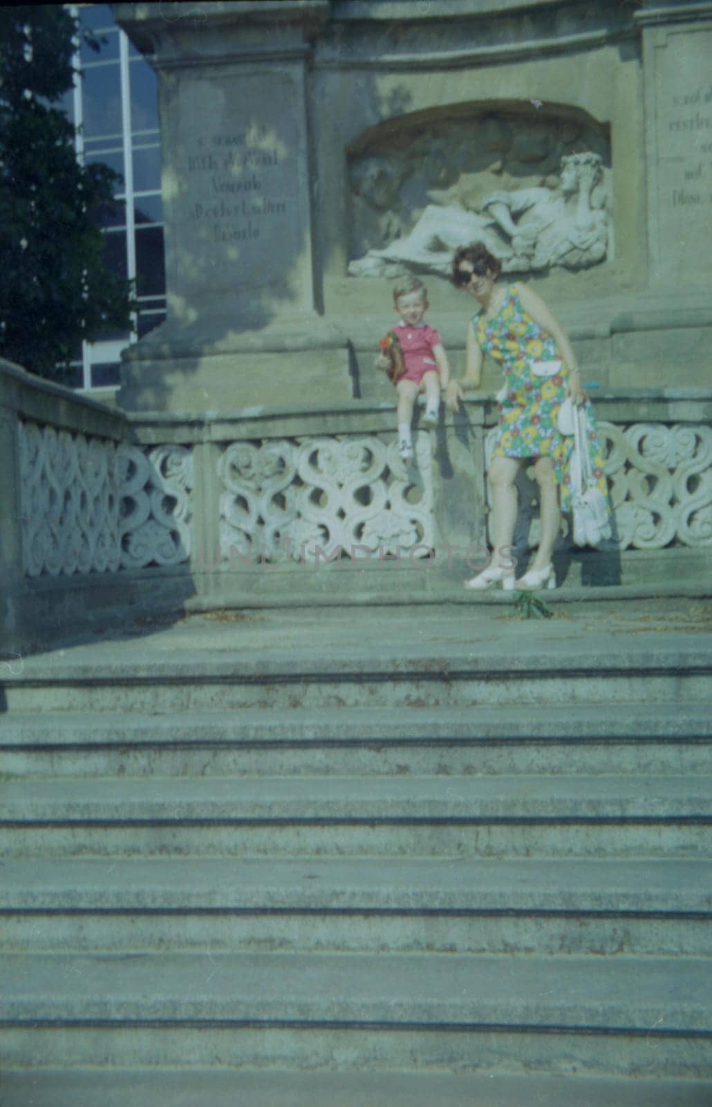 THE CZECHOSLOVAK SOCIALIST REPUBLIC - 1973: Retro photo shows mother and son with toy outdoors.