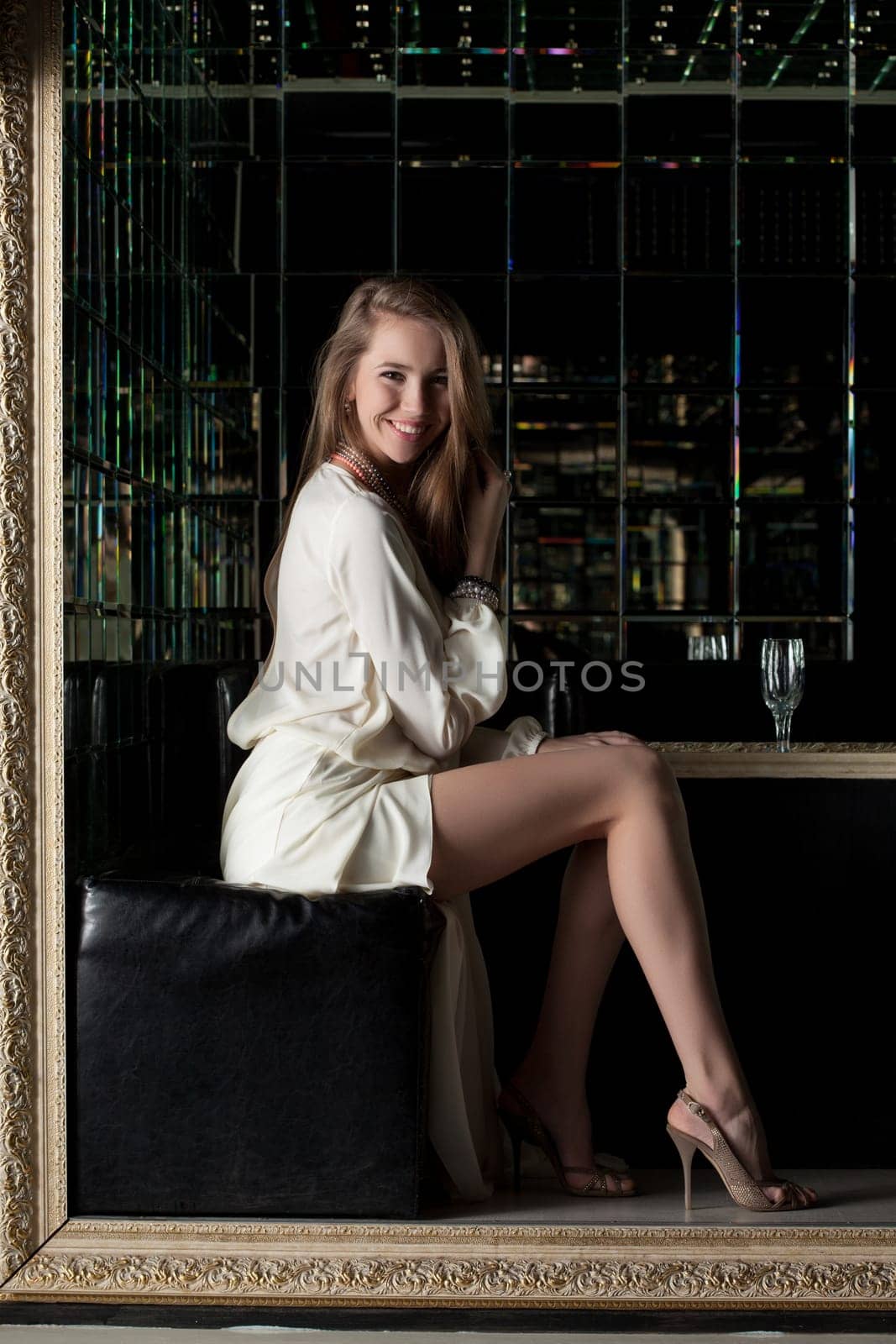 Portrait of beautiful young woman in nightclub - white fashion dress