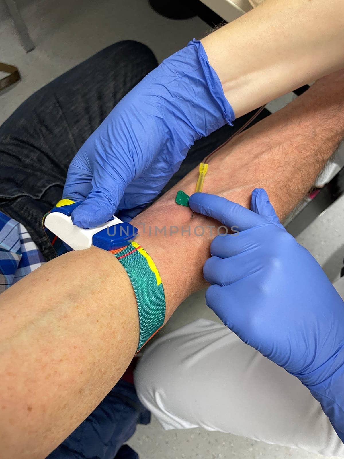 a nurse, doctor or medical technologist in blue gloves taking a blood sample from a patient in a hospital. High quality photo