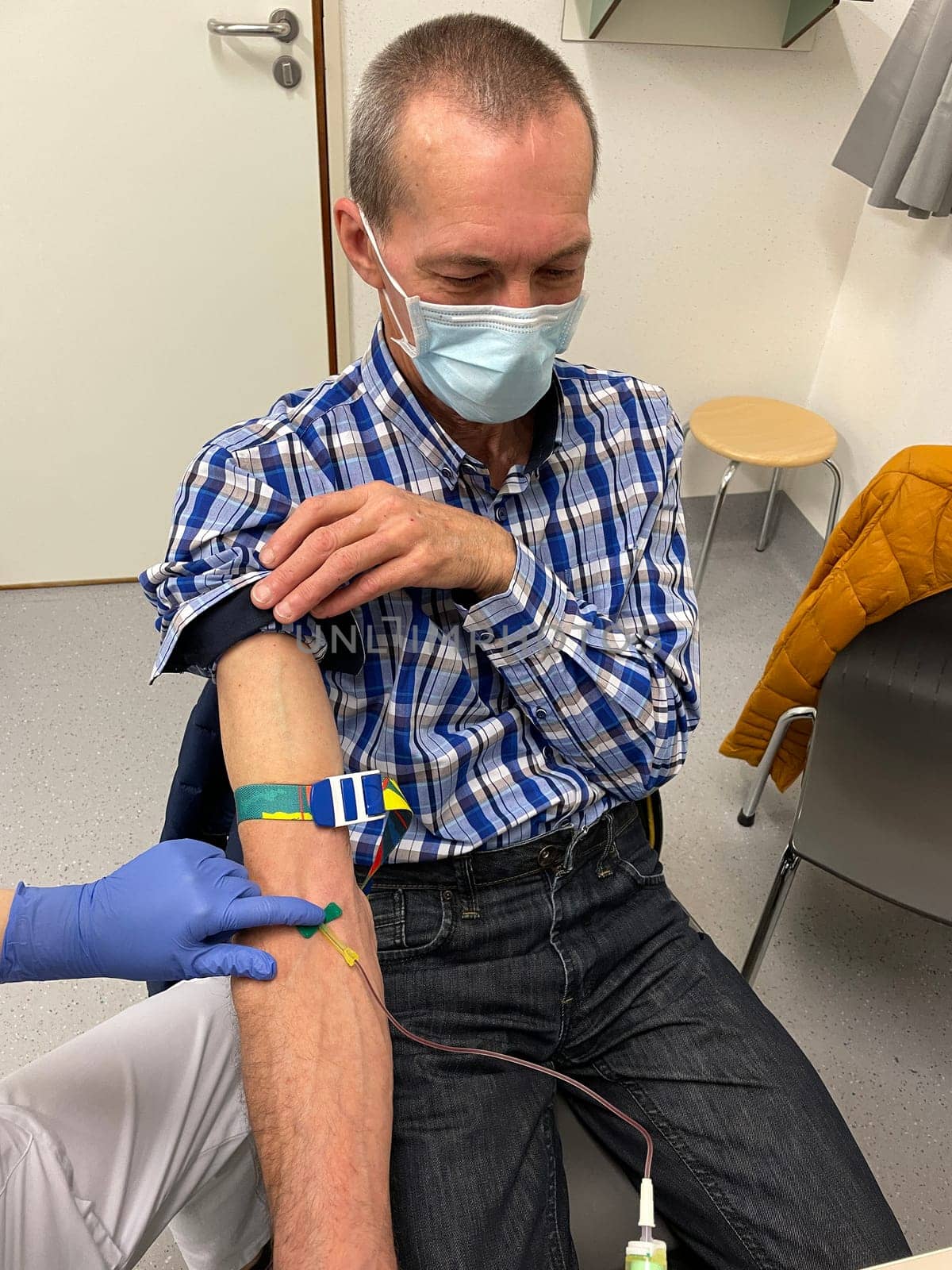 a nurse, doctor or medical technologist in blue gloves taking a blood sample from a patient in a hospital. High quality photo