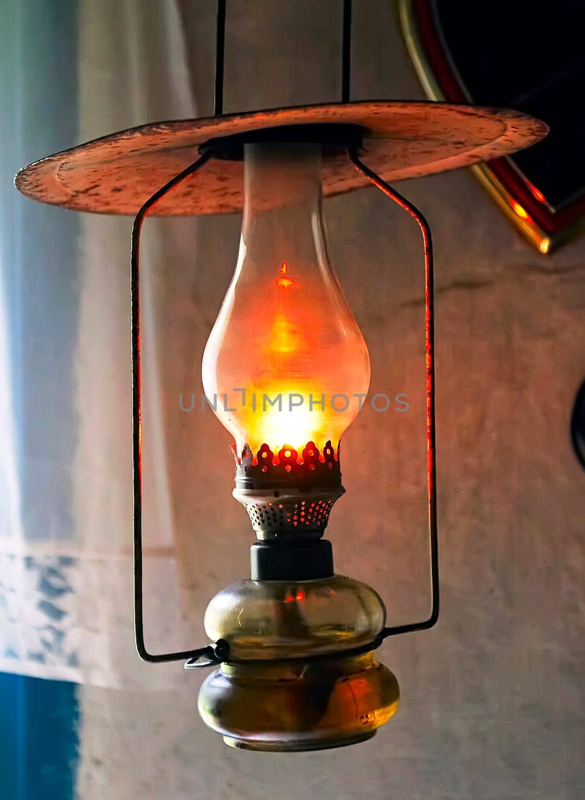 A kerosene lamp illuminating the darkness. A vintage lamp hangs in an old house.