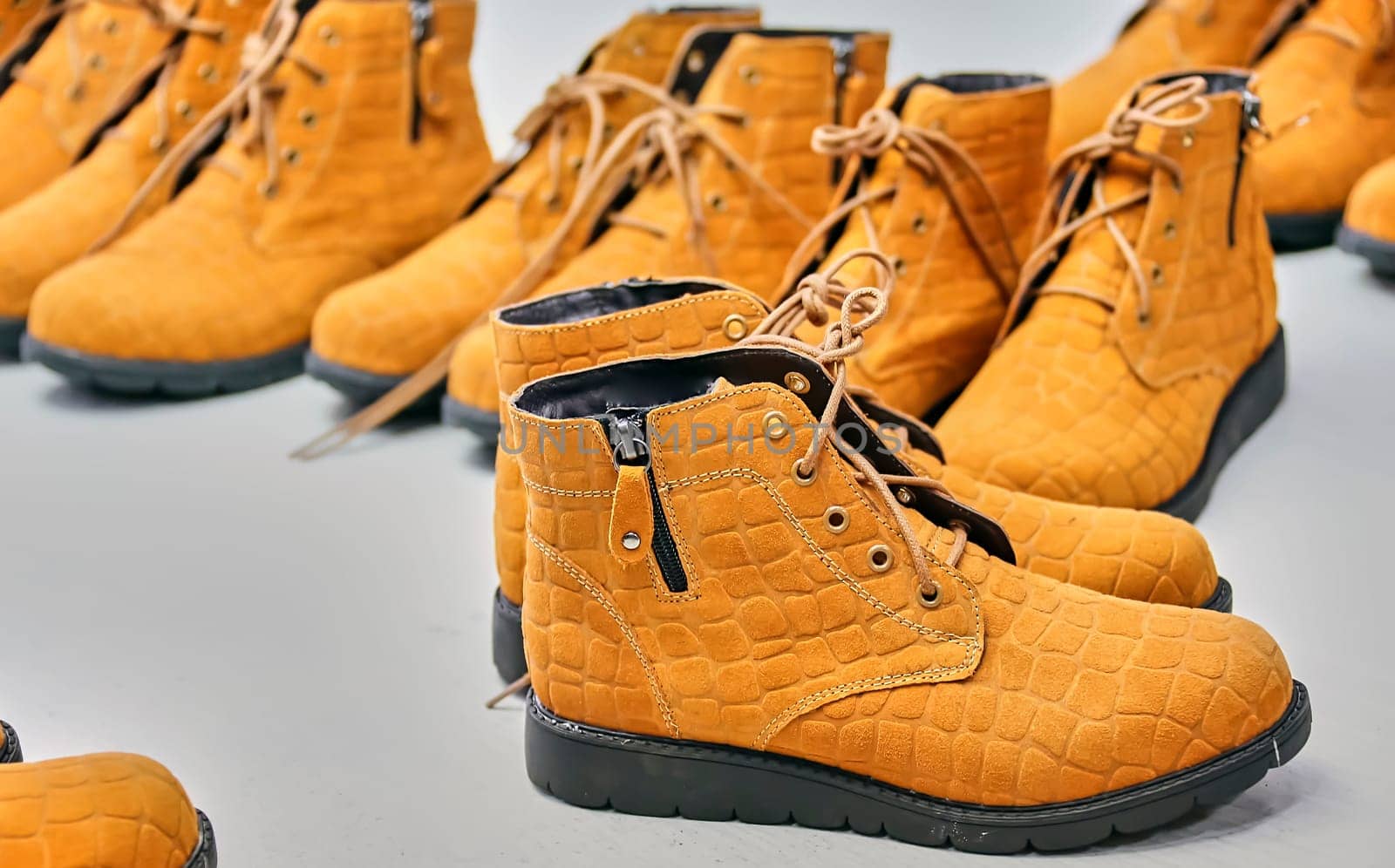 Checking the quality of shoes in a shoe factory. Yellow boots, finished shoes.