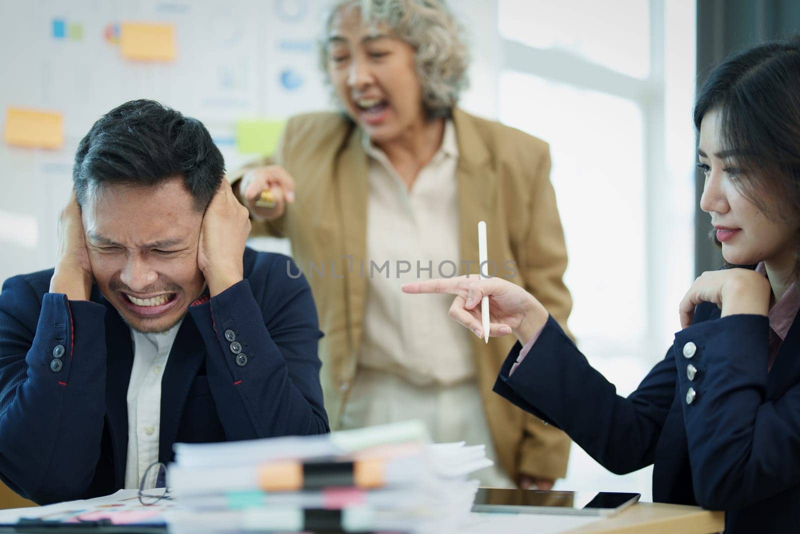 An image of an Asian male employee looking worried and sad about being scolded by his boss for failing to meet sales targets, concept of disappointment and failure in his career by Manastrong