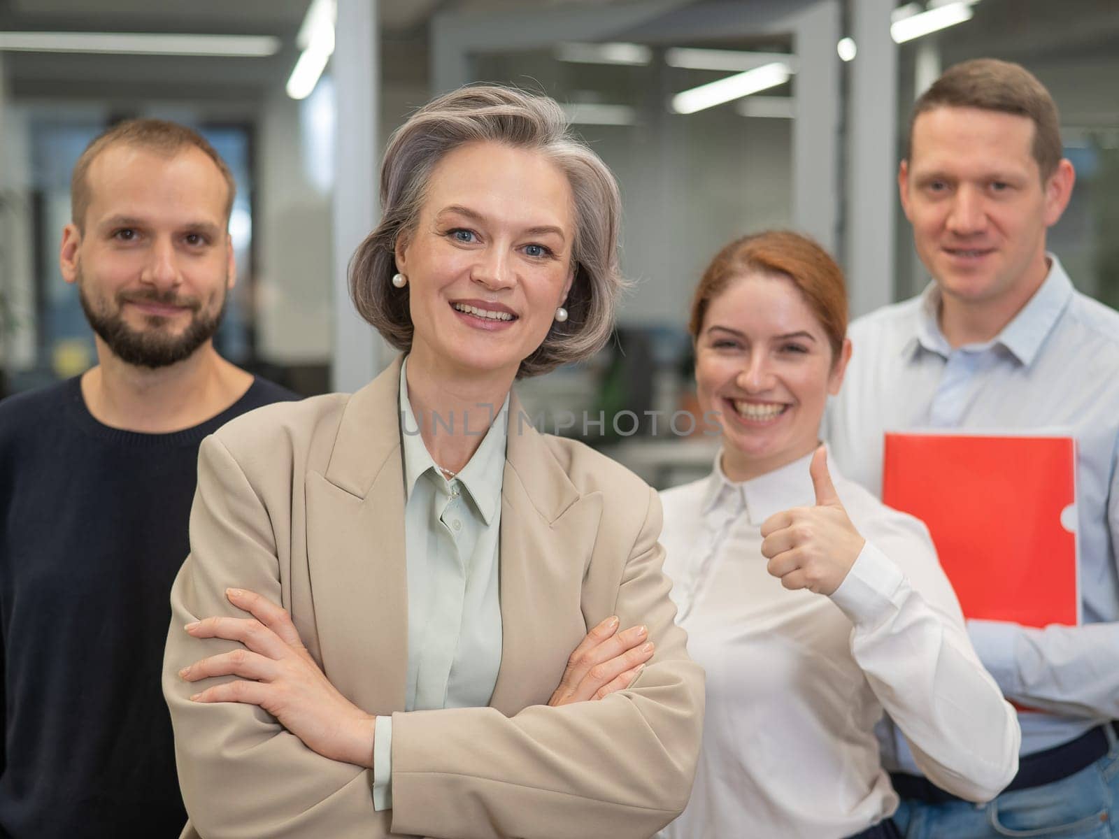 Portrait of four office workers. A gray-haired mature woman, a Caucasian man, a bearded man and a red-haired woman. by mrwed54