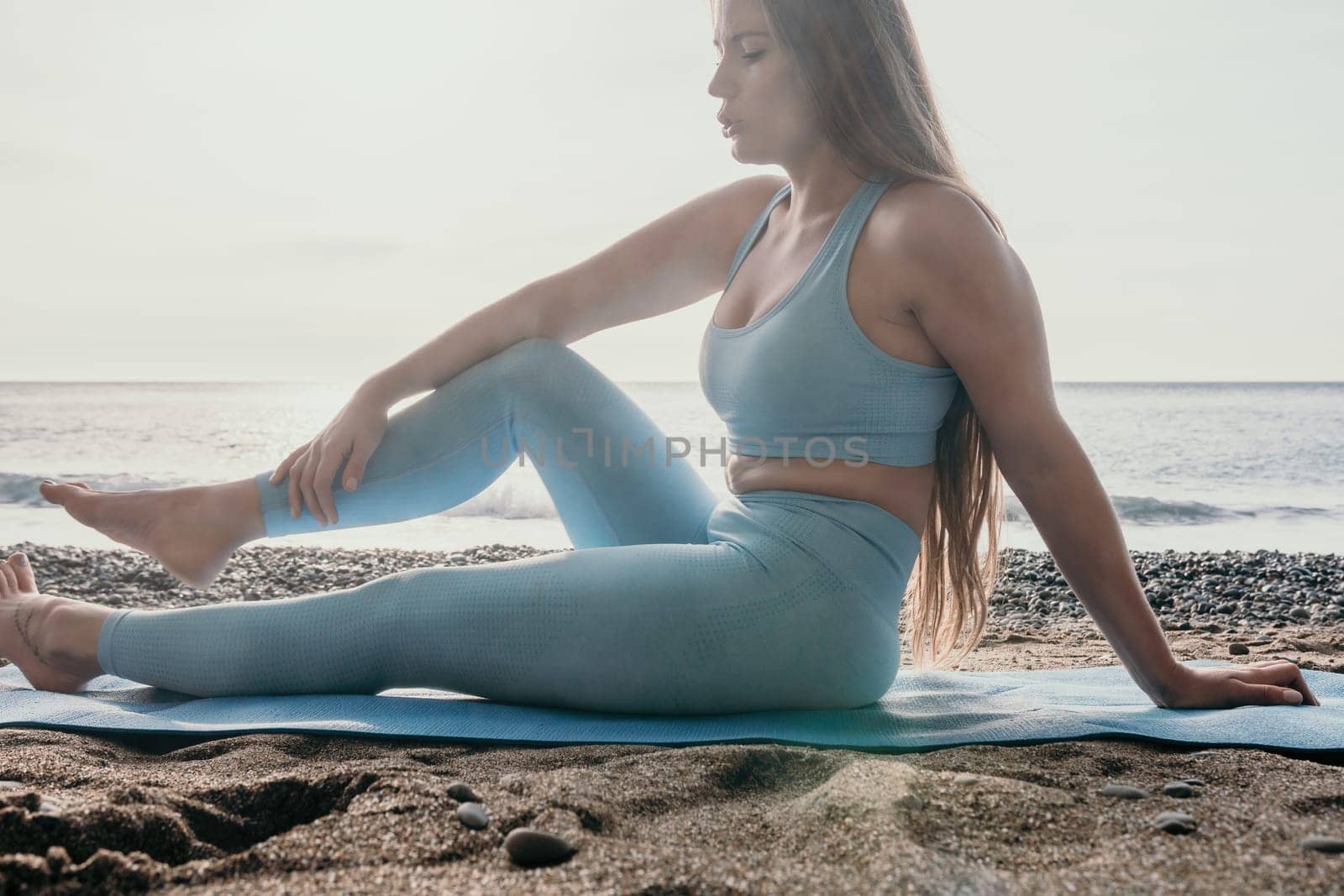 Woman sea pilates. Sporty happy middle aged woman practicing fitness on beach near sea, smiling active female training on yoga mat outside, enjoying healthy lifestyle, harmony and meditation. by panophotograph