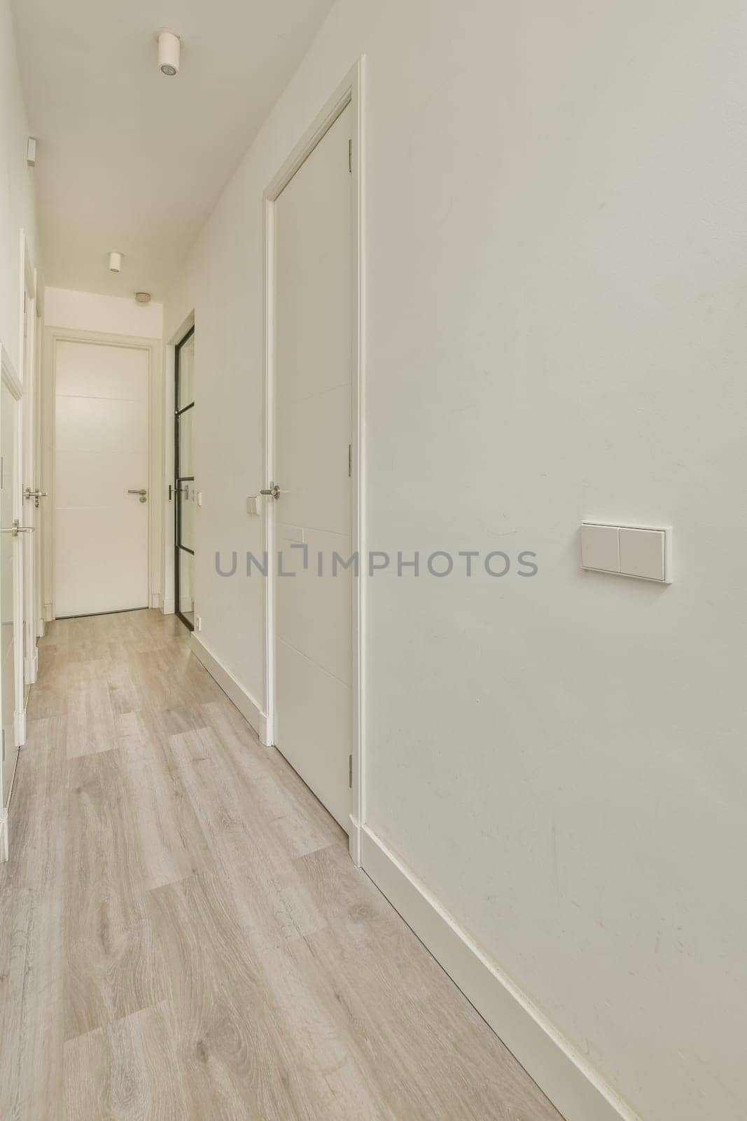 an empty hallway with white walls and wood floors by casamedia