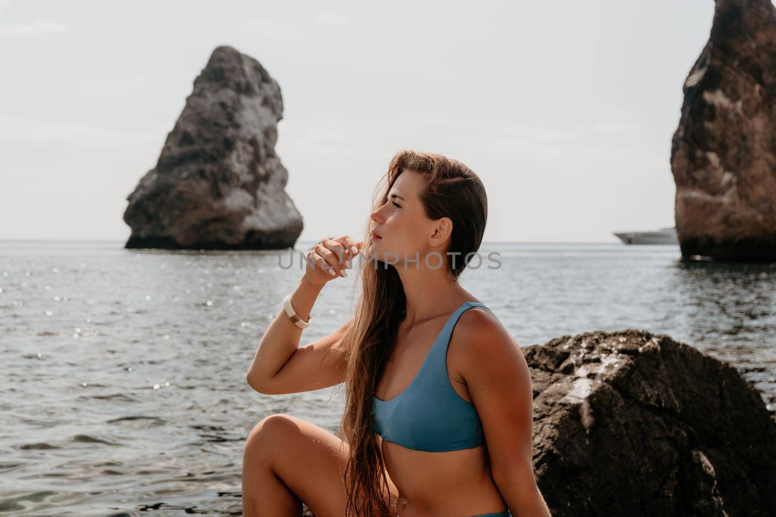 Woman travel sea. Young Happy woman in a long red dress posing on a beach near the sea on background of volcanic rocks, like in Iceland, sharing travel adventure journey