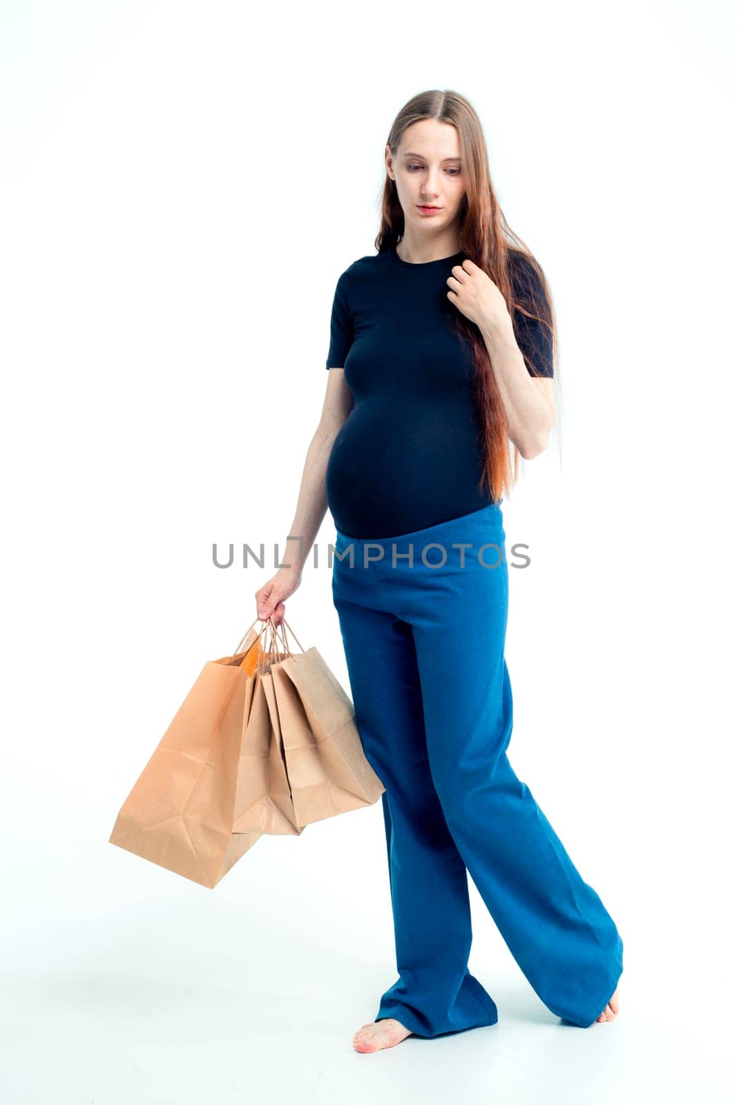 smiling beautiful young pregnant woman holding paper bags by kajasja