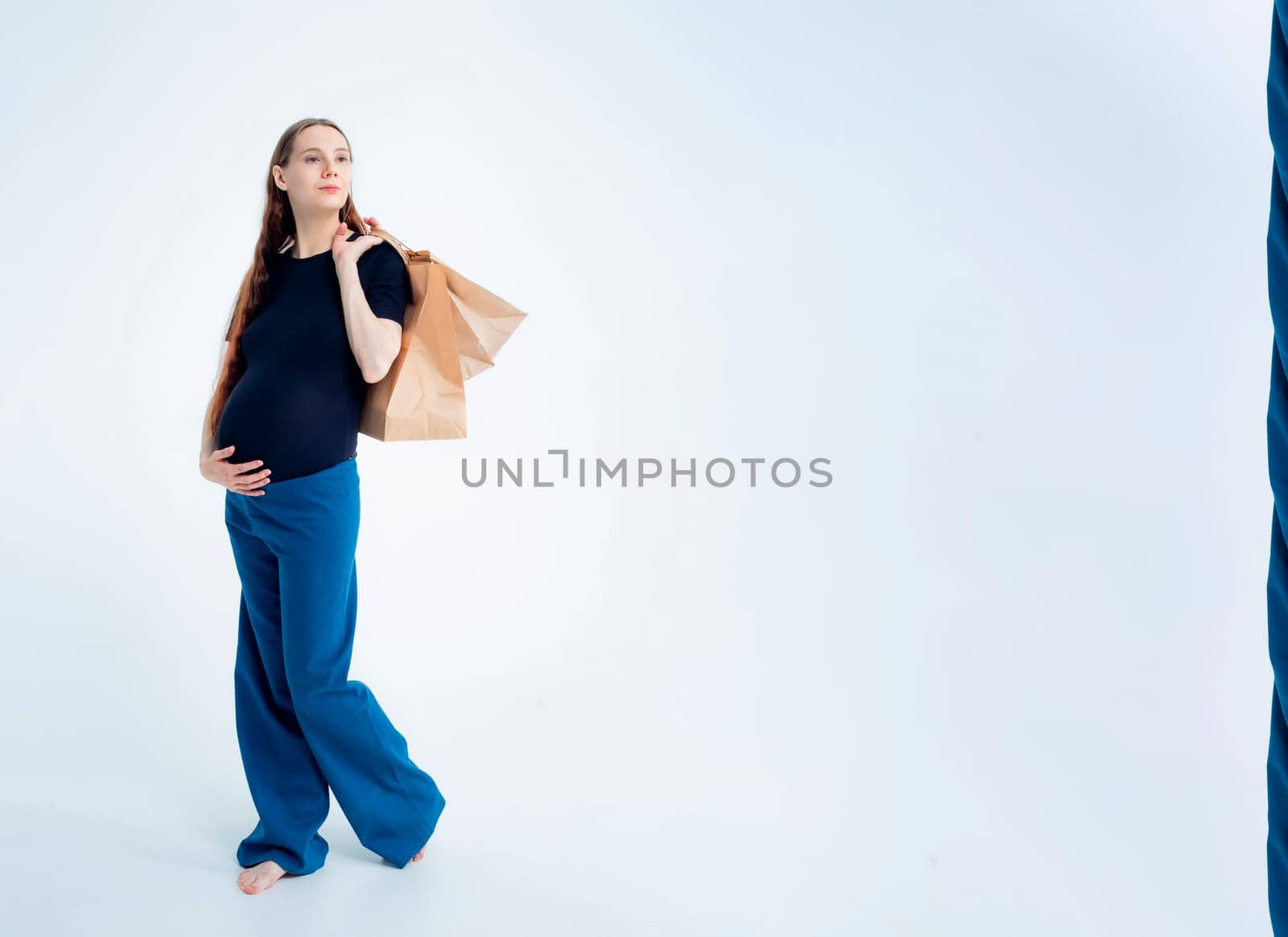 smiling beautiful young pregnant woman holding paper bags by kajasja