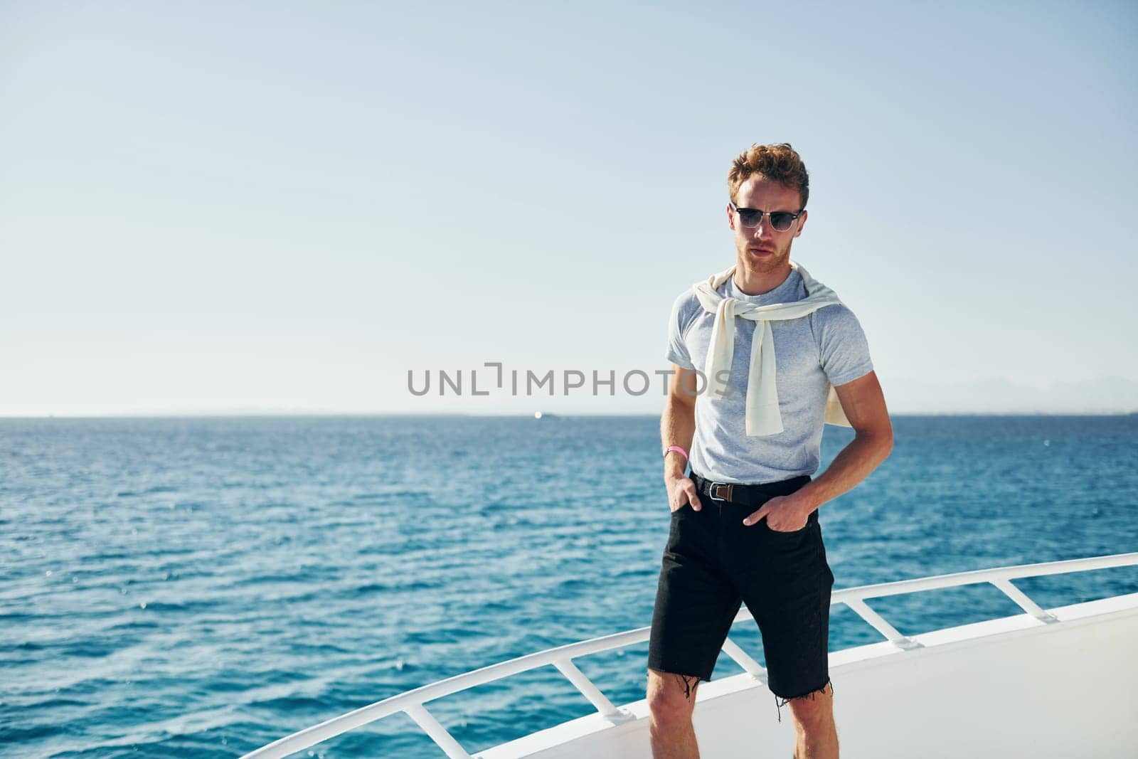 Young male tourist is on the yacht on the sea. Conception of vacation.