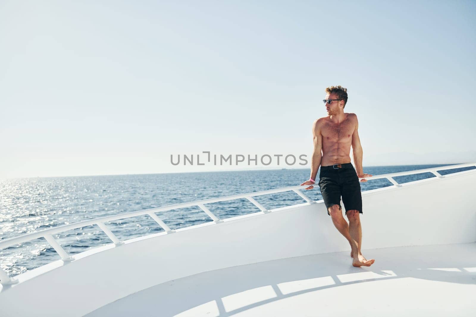 Young male tourist is on the yacht on the sea. Conception of vacation by Standret