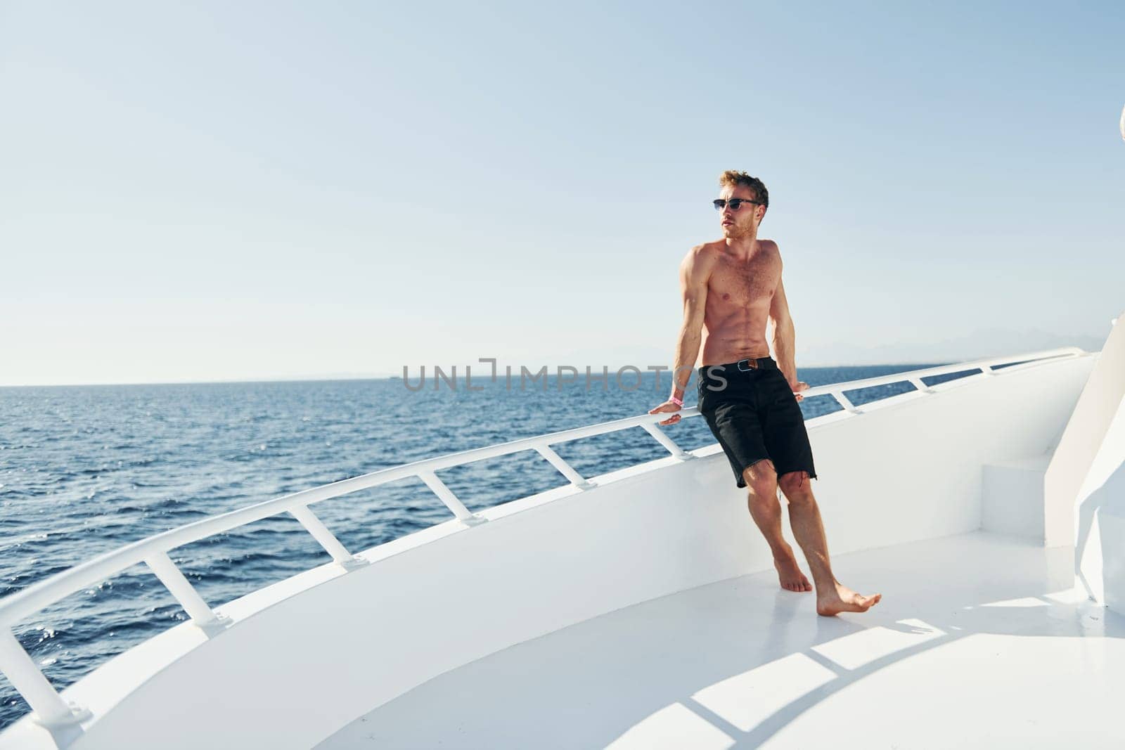 Young male tourist is on the yacht on the sea. Conception of vacation by Standret