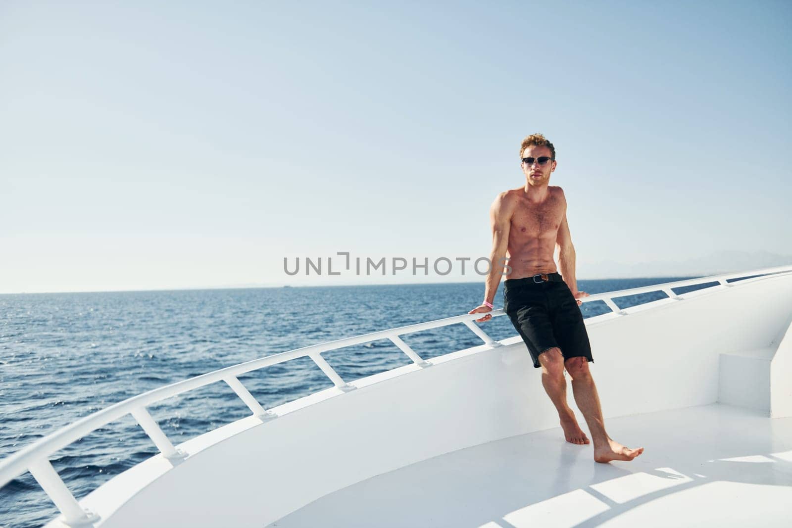 Young male tourist is on the yacht on the sea. Conception of vacation by Standret