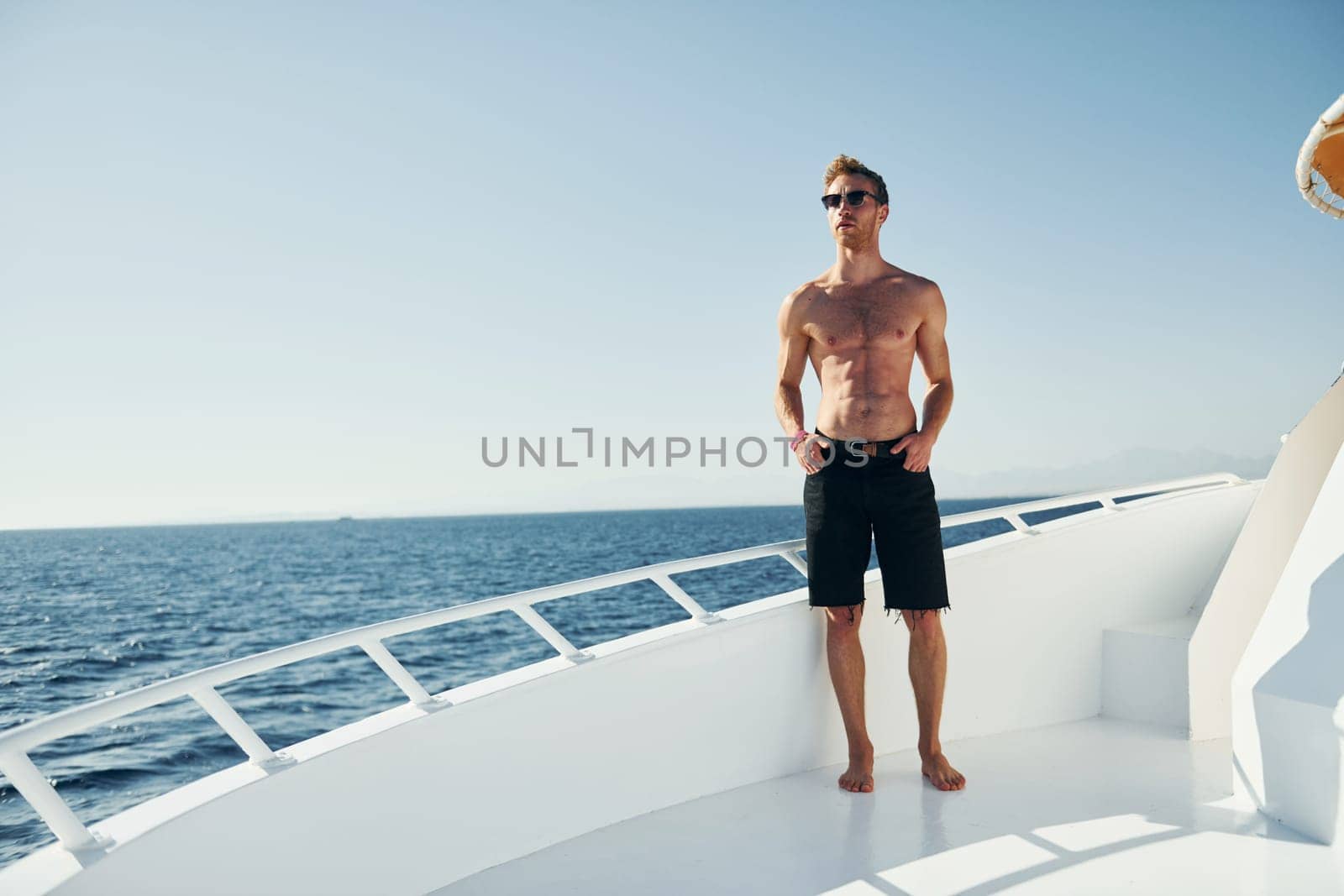 Young male tourist is on the yacht on the sea. Conception of vacation.