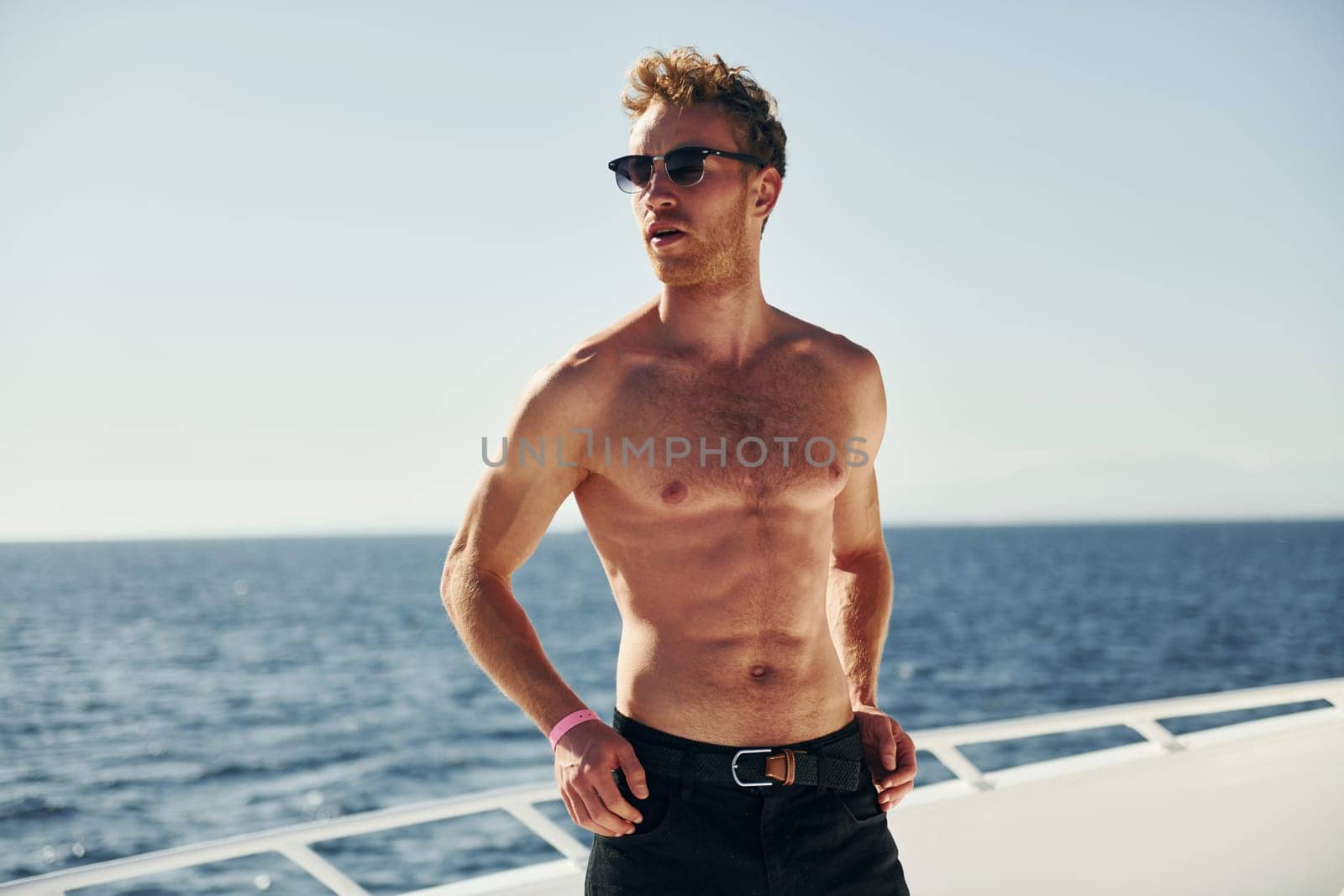 In sunglasses. Young male tourist is on the yacht on the sea. Conception of vacation.