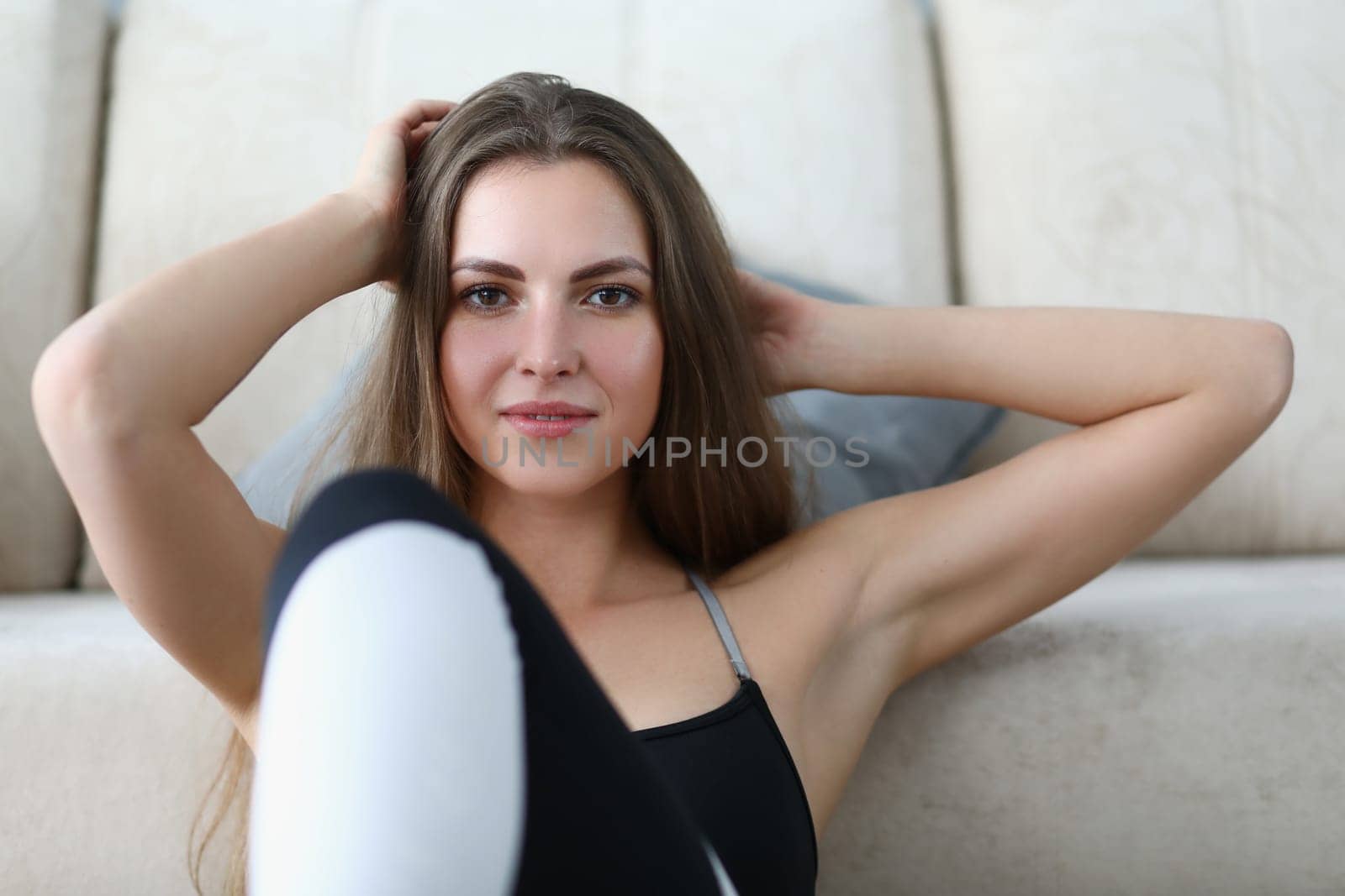 Portrait of beautiful young woman in sportswear at home by kuprevich